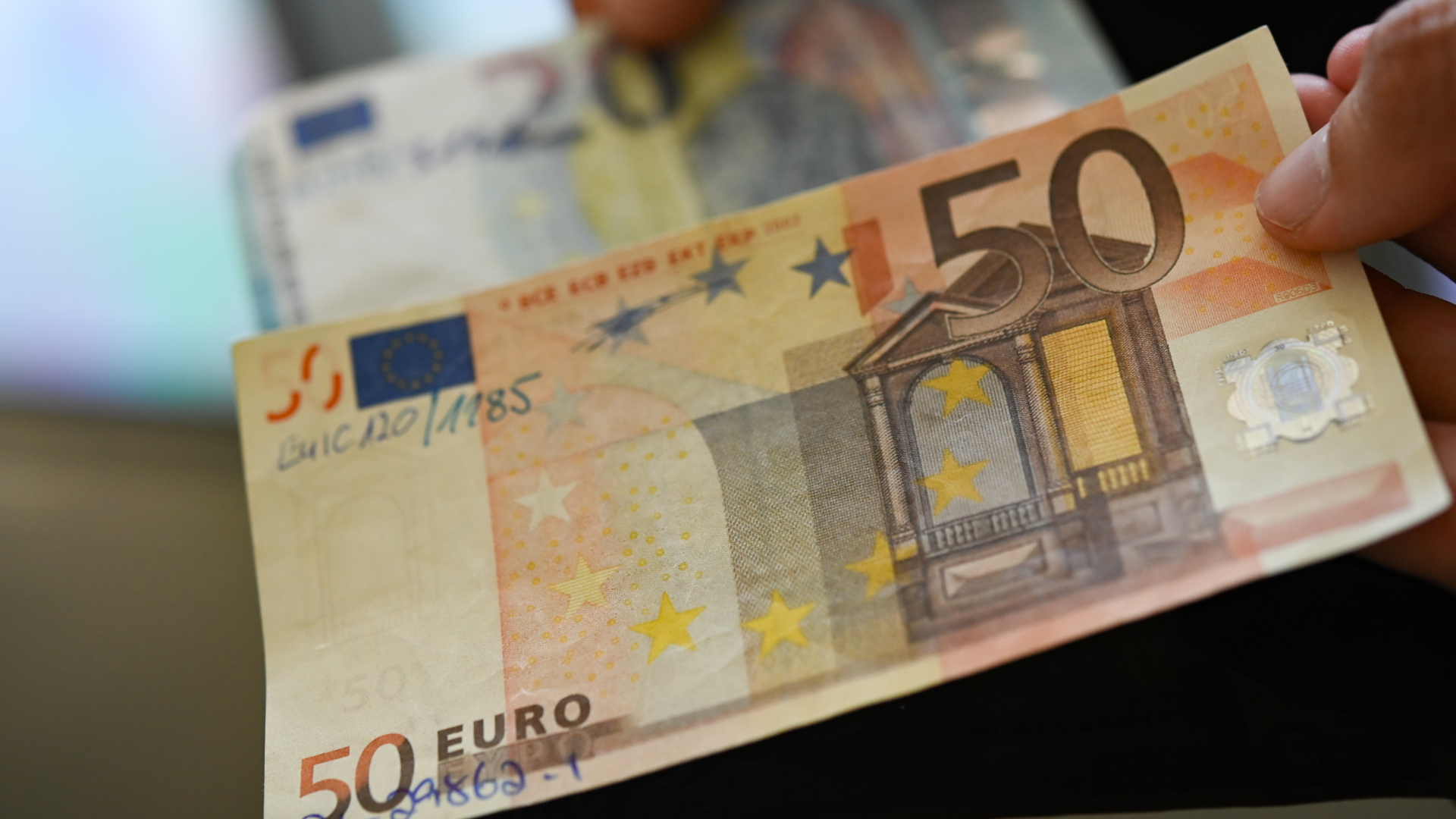 Hände halten eine gefälschte 50-Euro-Banknote und eine gefälschte 20-Euro-Banknote | dpa