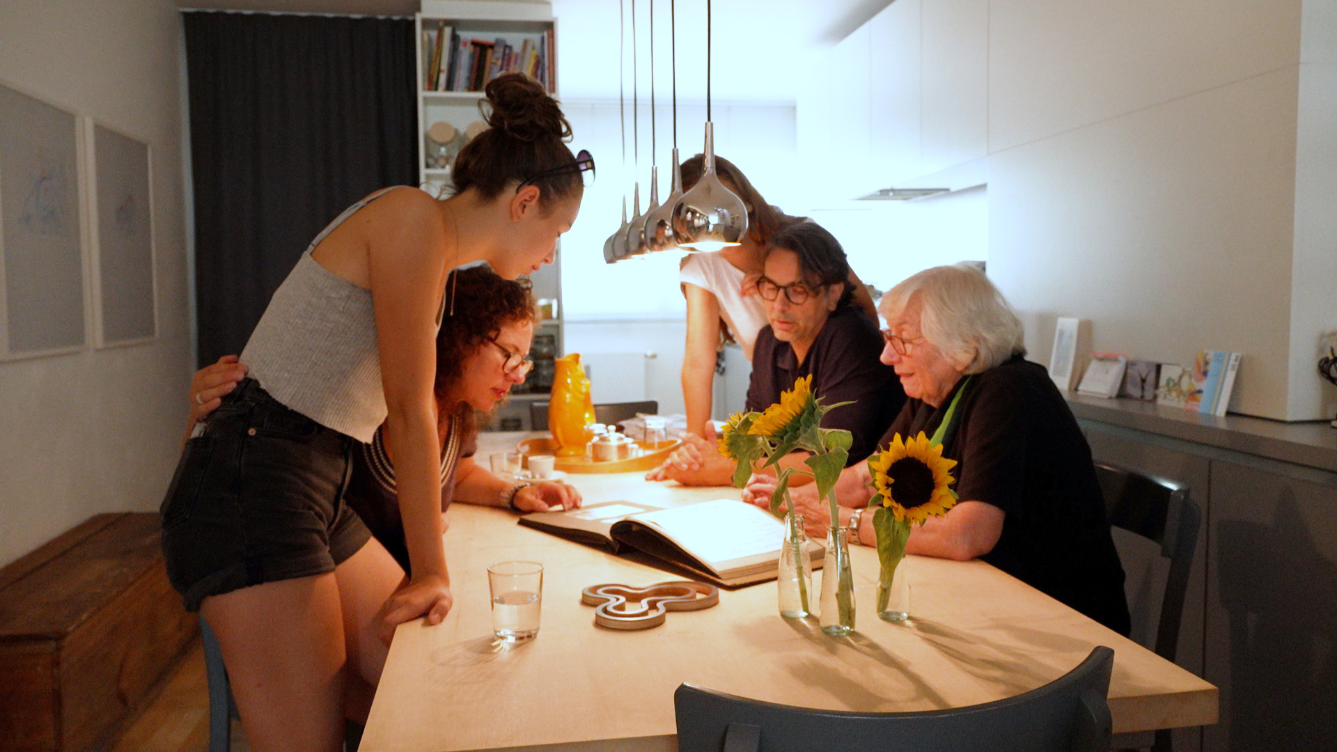 Familie Niese blättert durch ein Fotoalbum. | BR/Steinbacher
