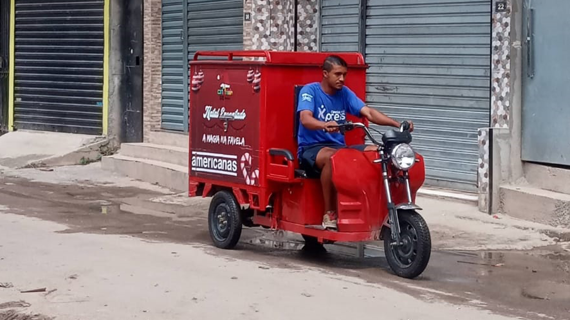 Auf seinem roten Dreirad liefert Jonathan Perreira Pakete nach Paraisópolis aus. | Projekt G10 Favelas