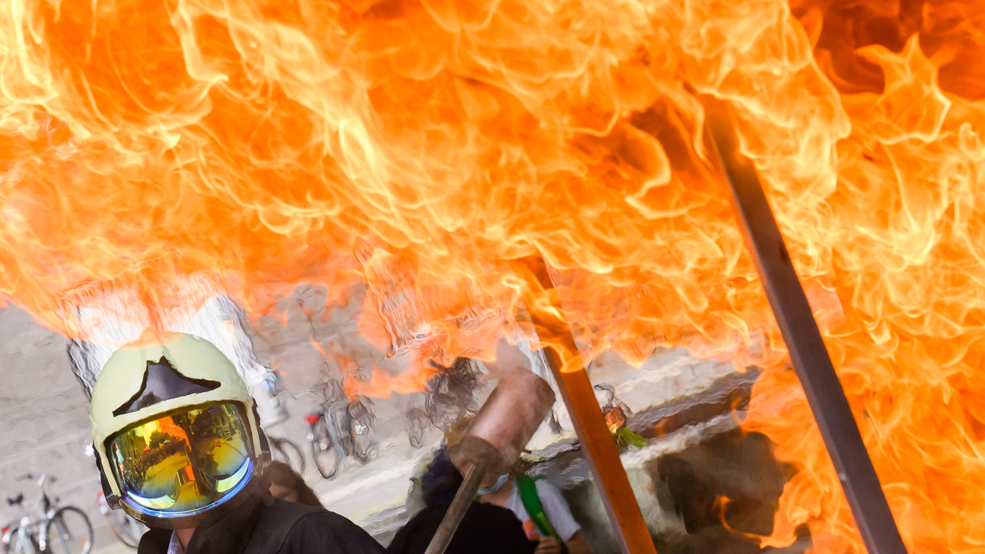 Flammen mit Feuerwehrmann, der einen Helm trägt. | dpa