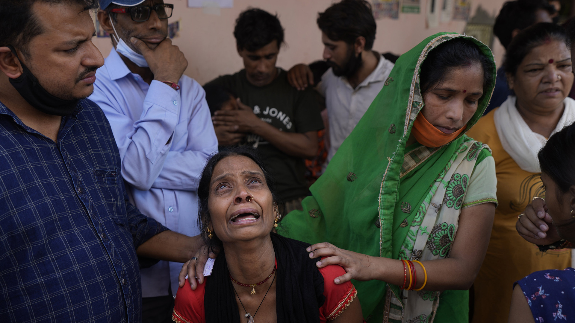 Eine Frau bangt weinend mit anderen um Angehörige, die zur Zeit des Brandes in dem Gebäude waren. | AP