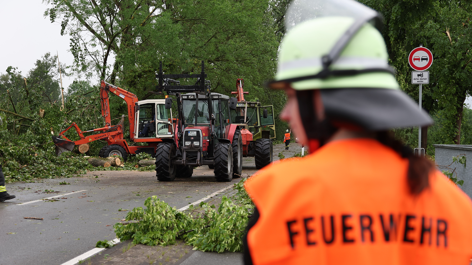 Feuerwehrleute entfernen bei Lippstadt (Nordrhein-Westfalen) Trümmer von einer Straße. | dpa