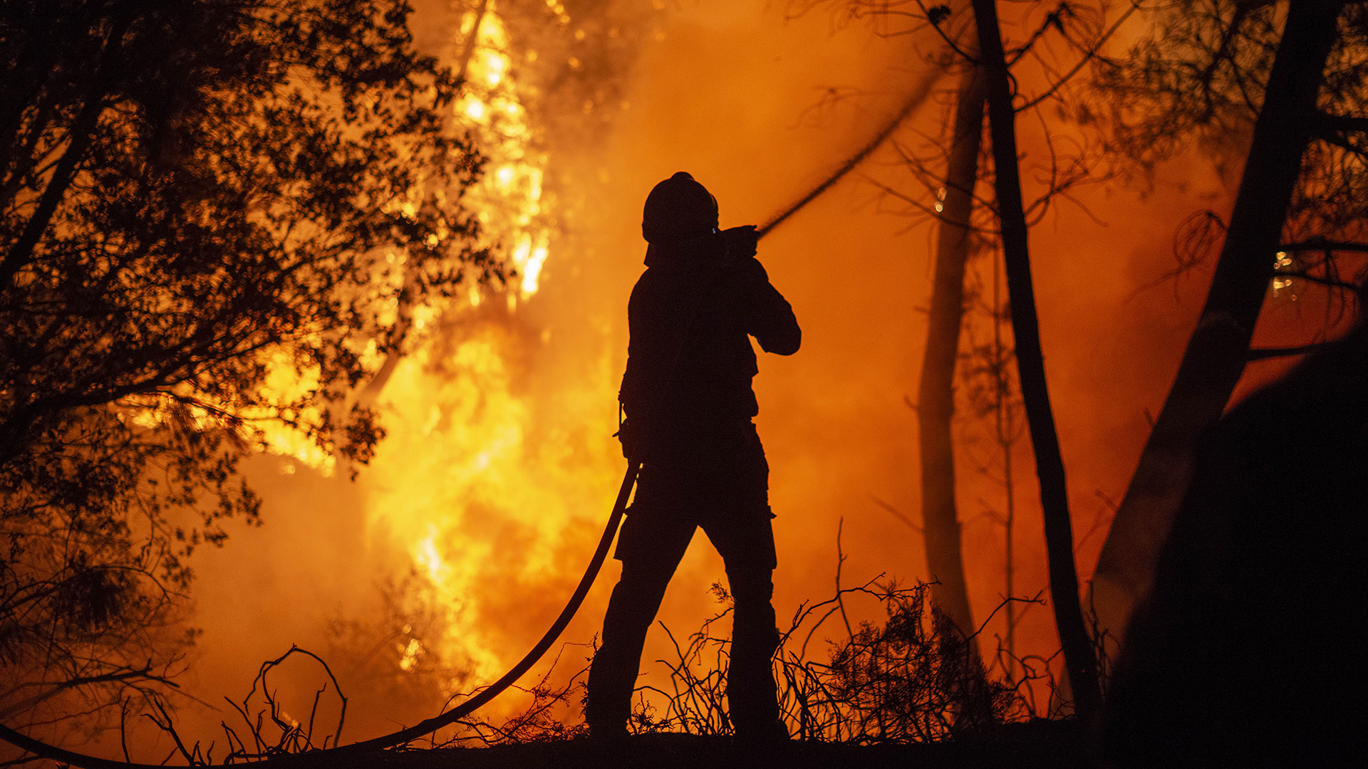 Ein Feuerwehrmann löscht ein Feuer in der Nähe der Gemeinde Castrelo de Mino, Galicien, Spanien