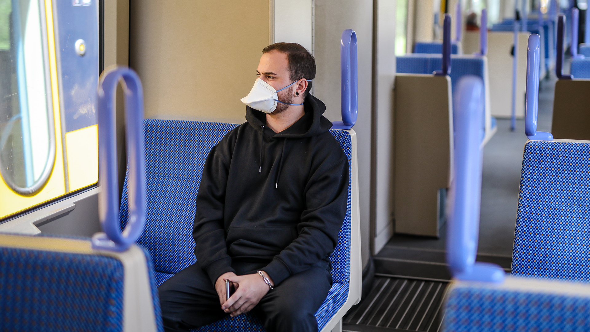 Ein junger Mann trägt in einer Stadtbahn eine Atemschutzmaske der Kategorie FFP2 | dpa