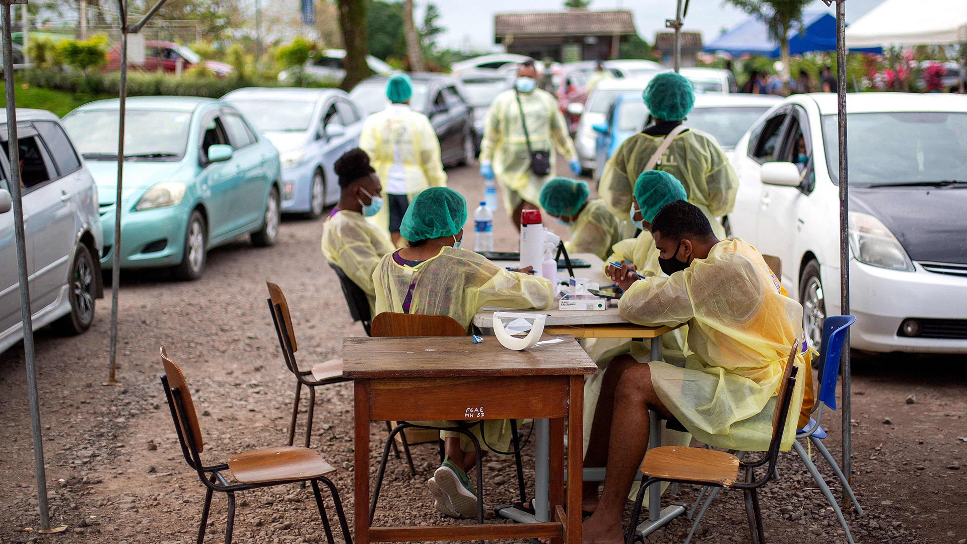 Mitarbeiter des Gesundheitsamts in Suva sitzen wartend auf Impfpatienten im Freien.
