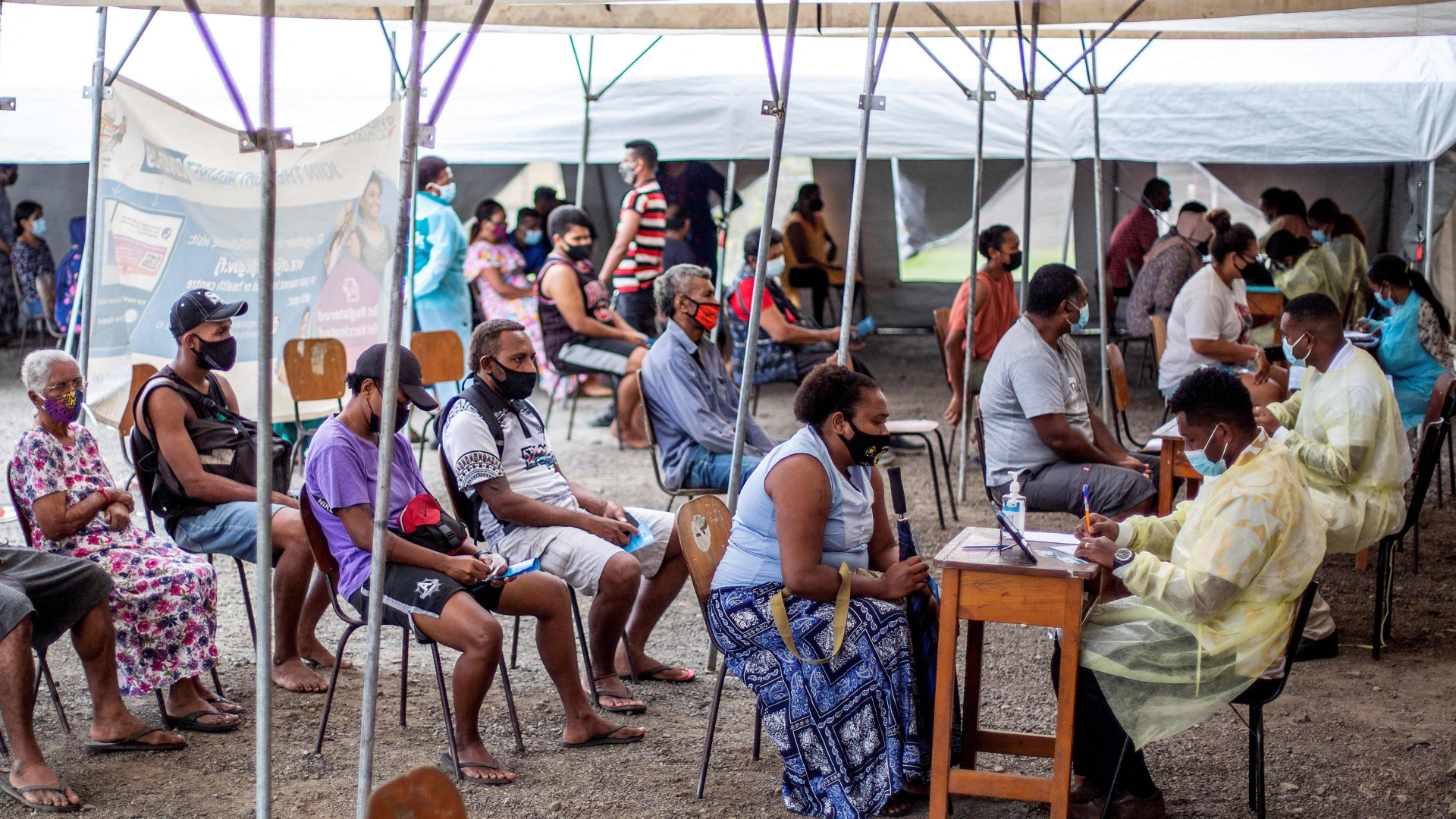 Menschen warten in einem Impfzentrum auf eine Corona-Impfung mit dem Präparat von AstraZeneca in Suva, Fidschi. | AFP