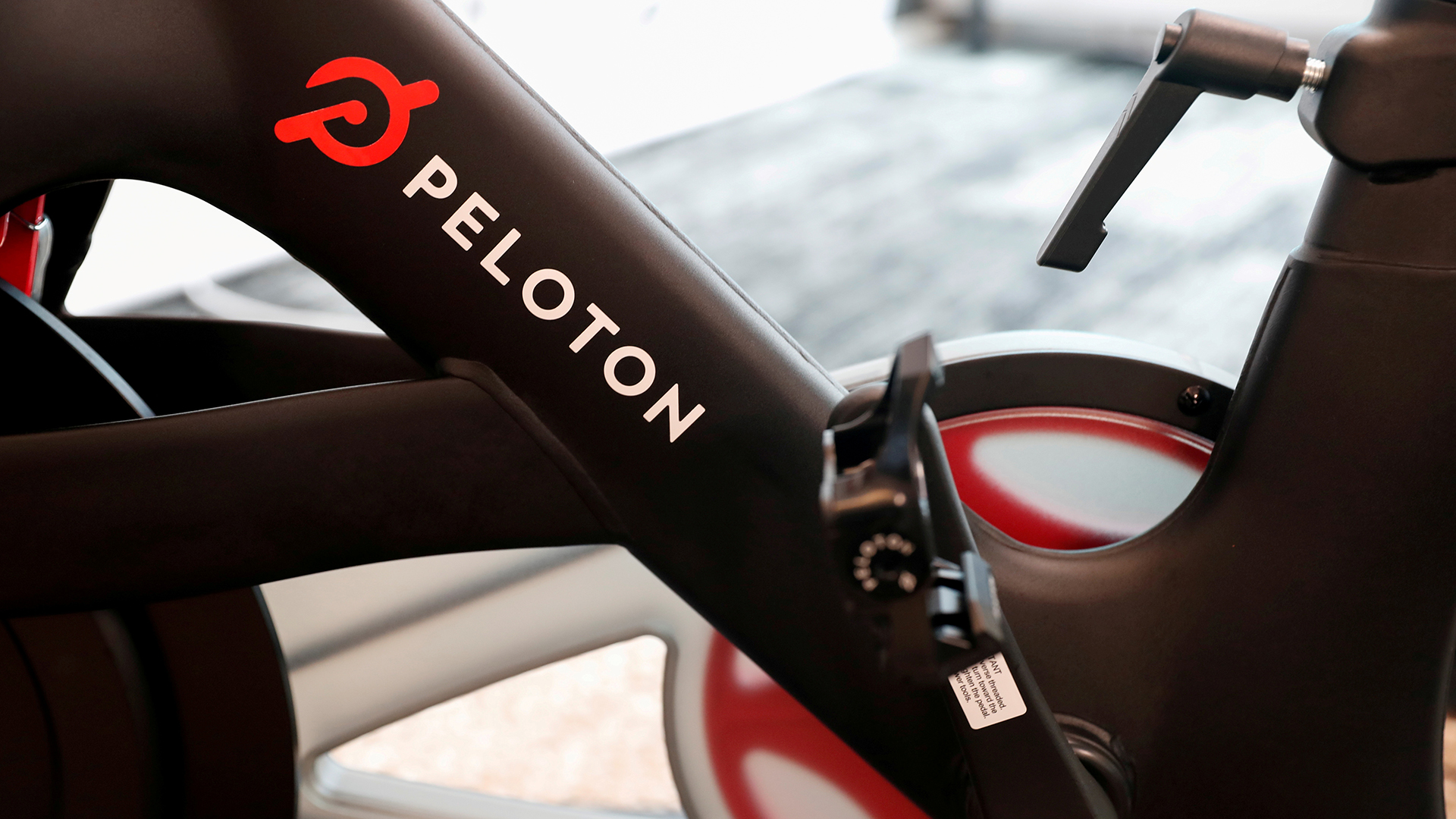 Das Logo der Firma Peloton steht auf einem stationären Trainingsrad. | REUTERS