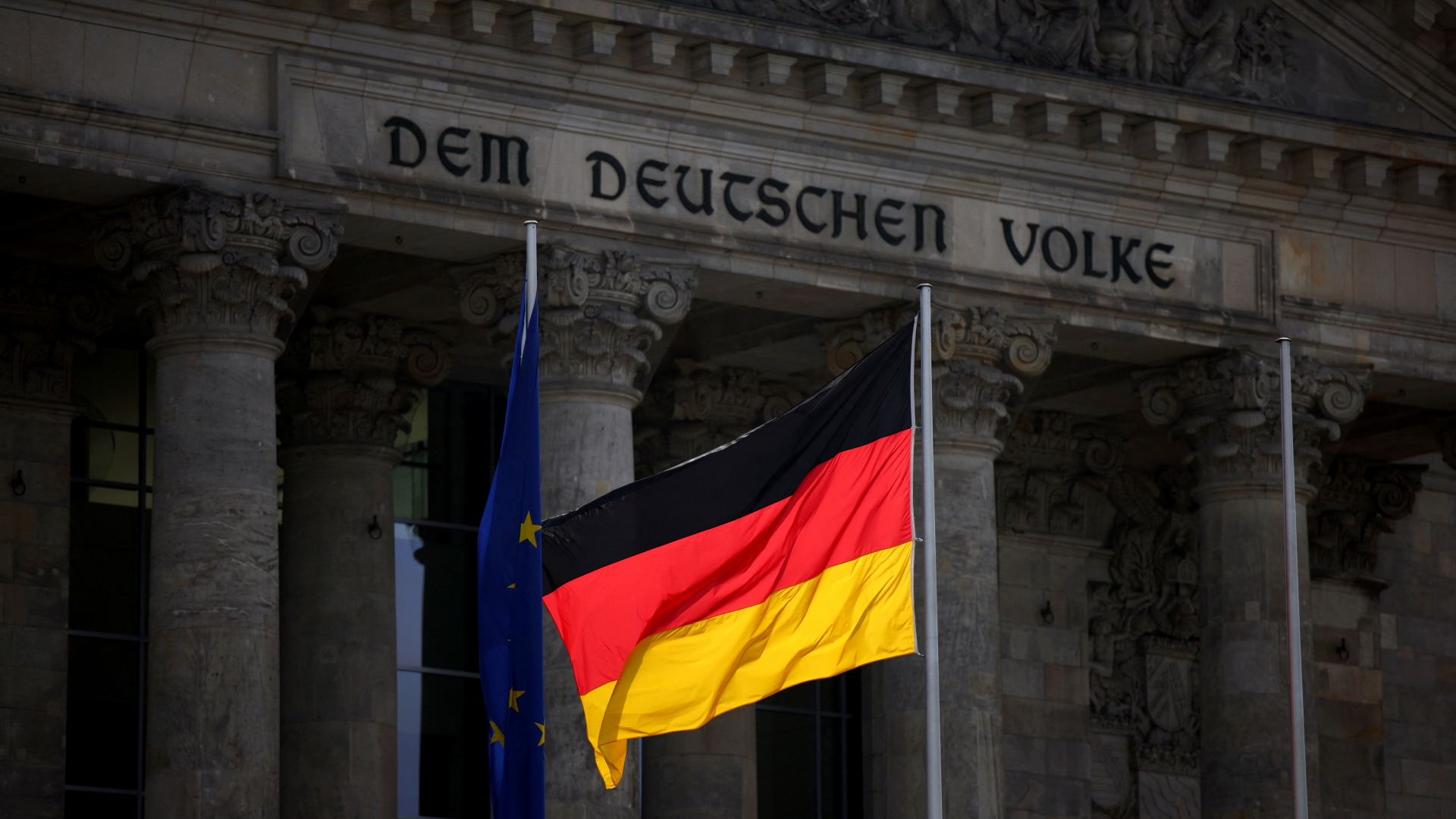 Eine deutsche Flagge weht vor dem Eingang des Reichstagsgebäudes in Berlin