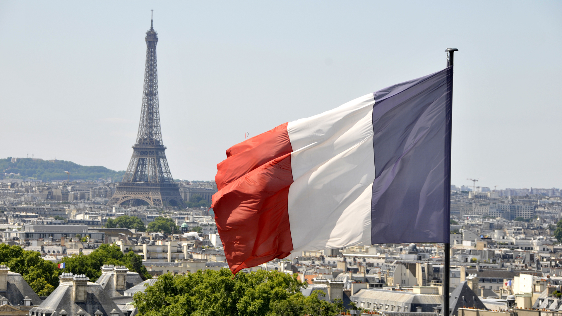 Die Flagge Frankreichs weht vor dem Eiffelturm in Paris. | picture alliance / abaca