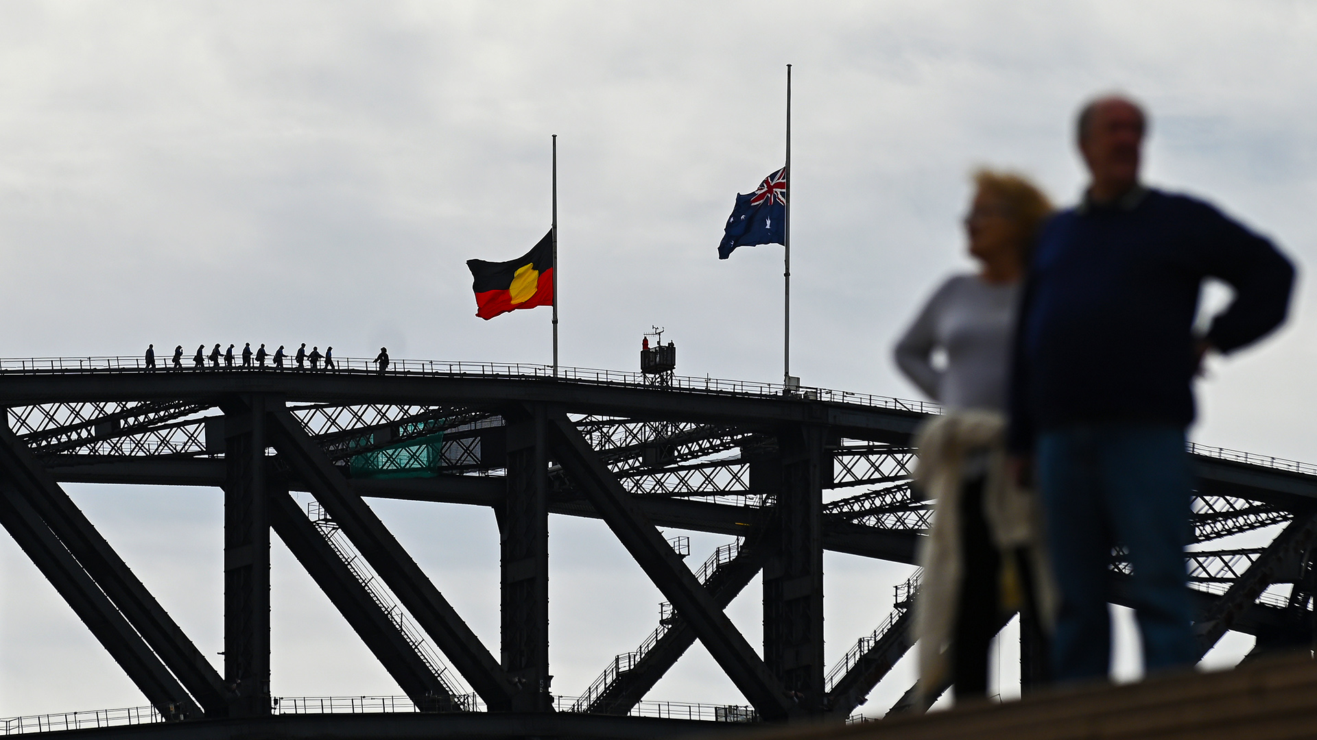 Die Flaggen der Aborigines und von Australien auf Halbmast auf der Harbour Bridge in Sidney