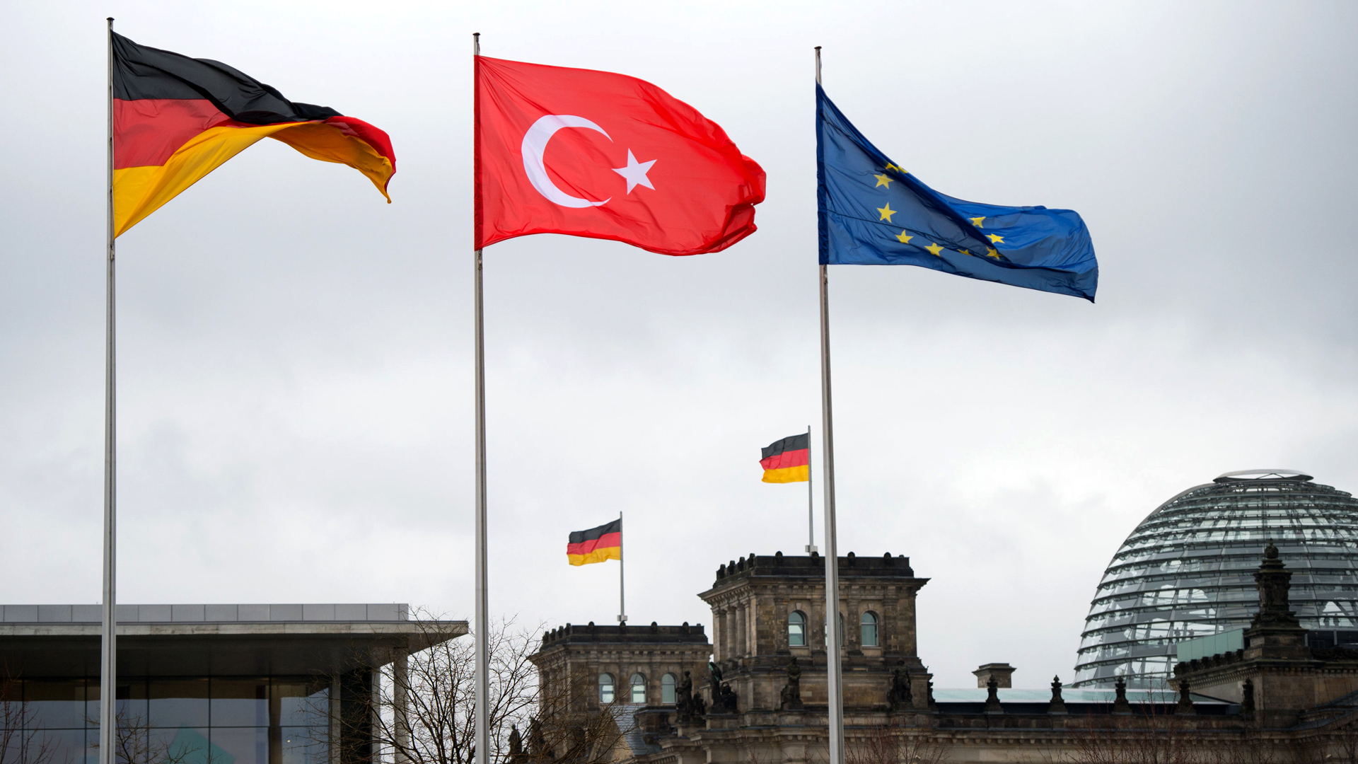 Die Flaggen Deutschlands, der Türkei und von Europa wehen vor dem Bundeskanzleramt in Berlin.