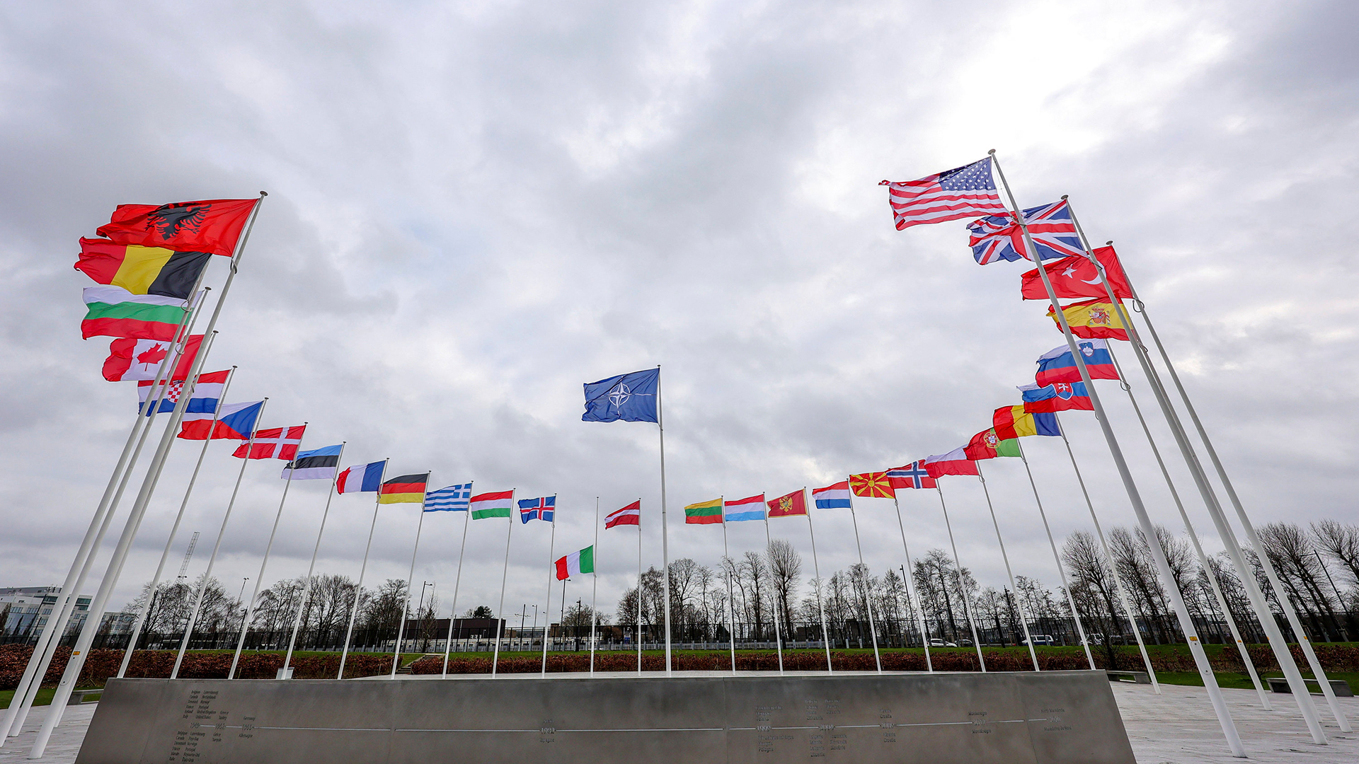 Vor dem NATO-Hauptquartier in Brüssel wehen die Flaggen der NATO-Mitgliedsländer im Wind.