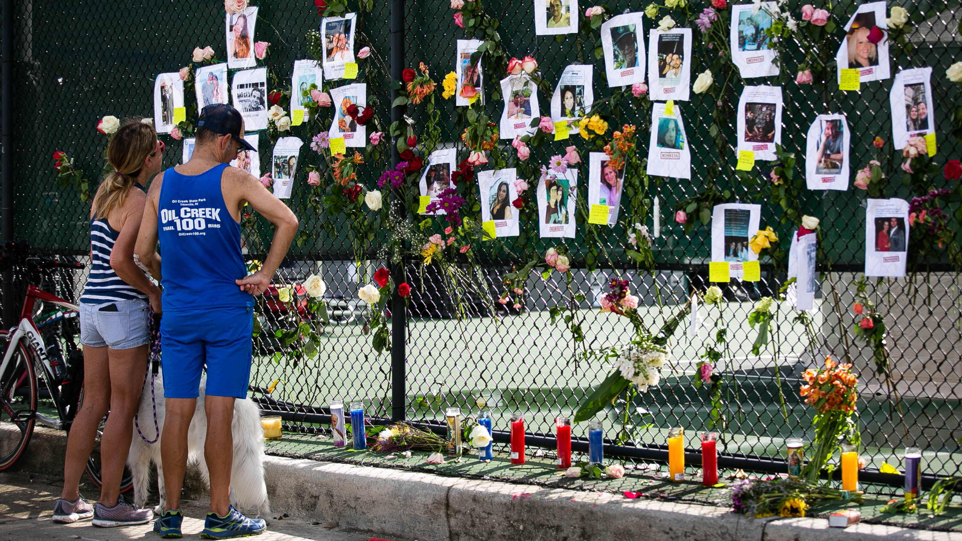 Nach dem Einsturz eines Wohnhauses in Surfside, Florida, haben Angehörige Bilder der Toten und Vermissten an einen Zaun gehängt. | AFP