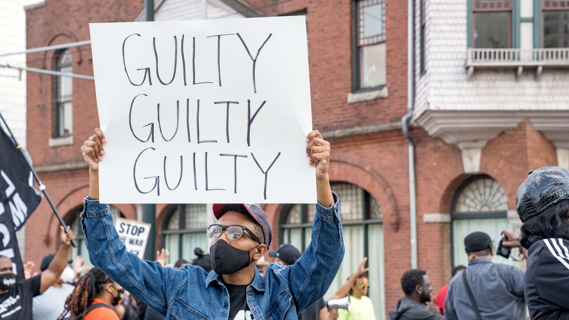 Ein Demonstrant in Atlanta hält ein Schild mit der Aufschrift "guilty, guilty, guilty" (schuldig, schuldig, schuldig) in die Höhe.