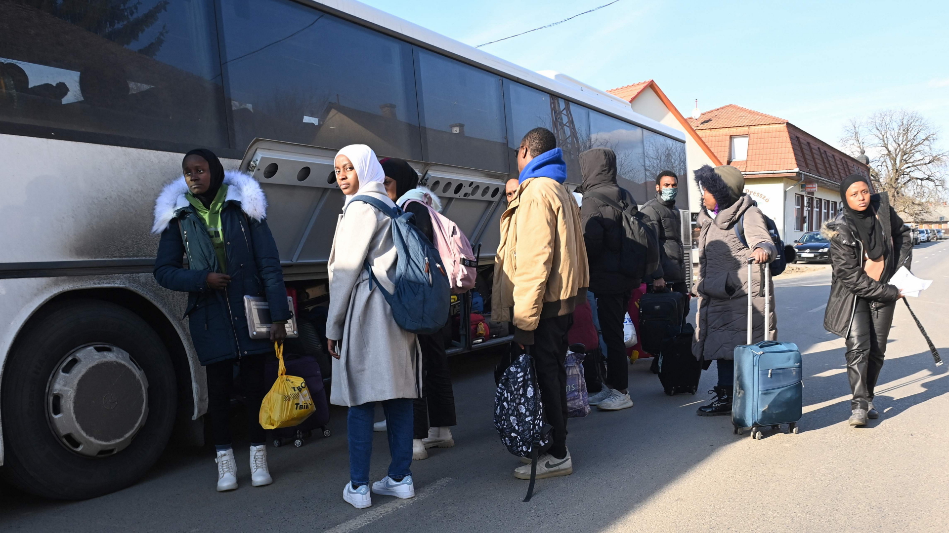 Geflüchtete Studierende aus der Ukraine verstauen ihr Gepäck in einem Bus nahe der ukrainisch-ungarischen Grenze. | AFP