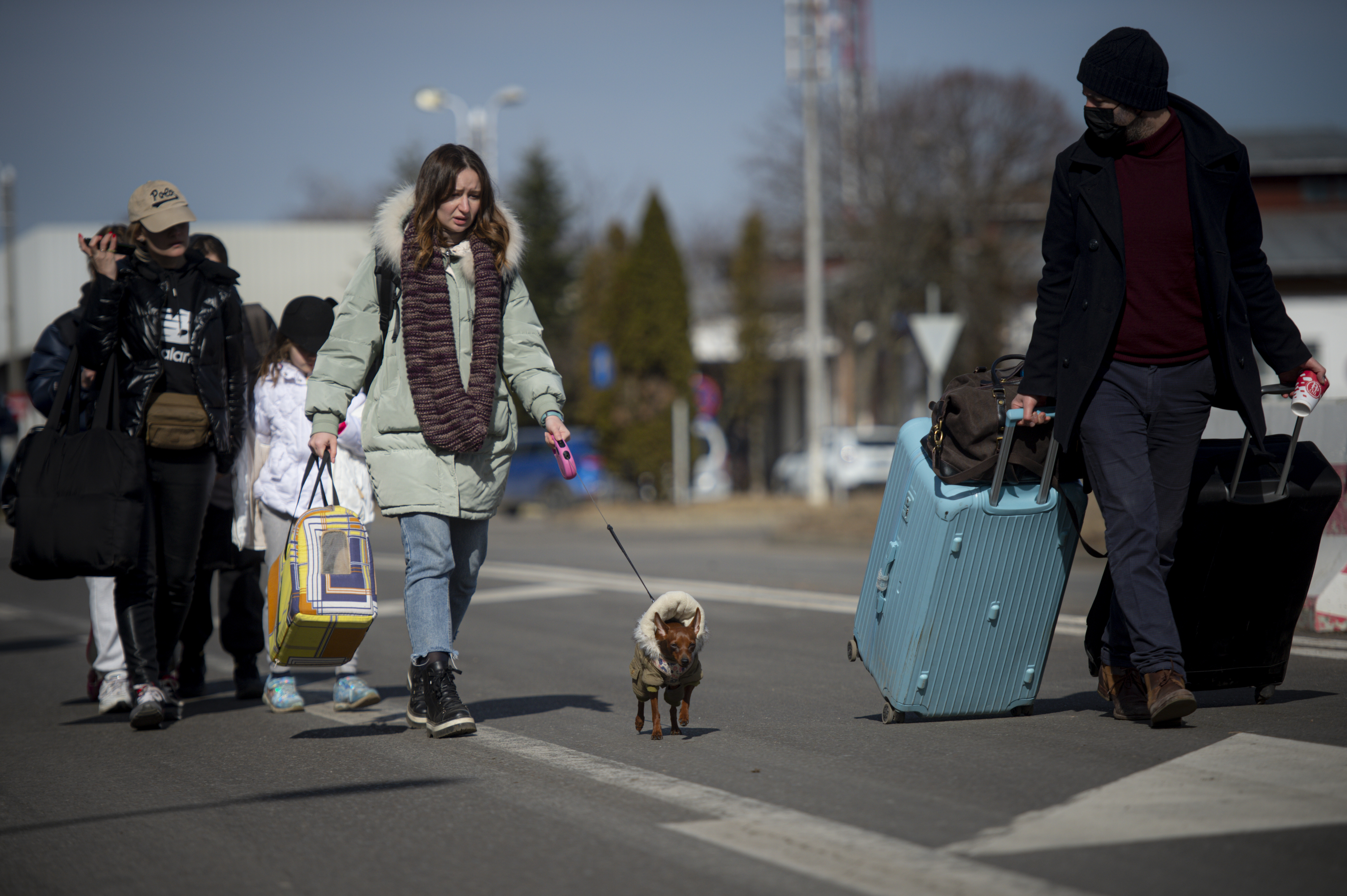Menschen gehen auf einer Straße in Siret, nachdem sie die Grenze zur Ukraine an der rumänisch-ukrainischen Grenze überquert haben.  | dpa