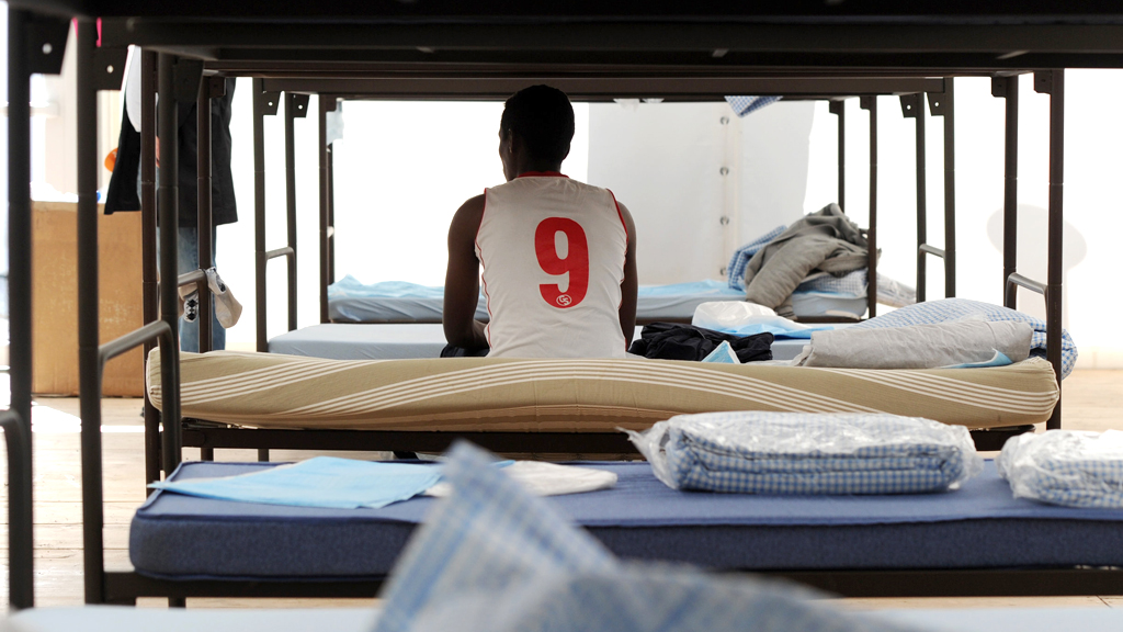 Flüchtling sitzt auf seinem Bett in einer Unterkunft in Bayern (Archivbild) | dpa