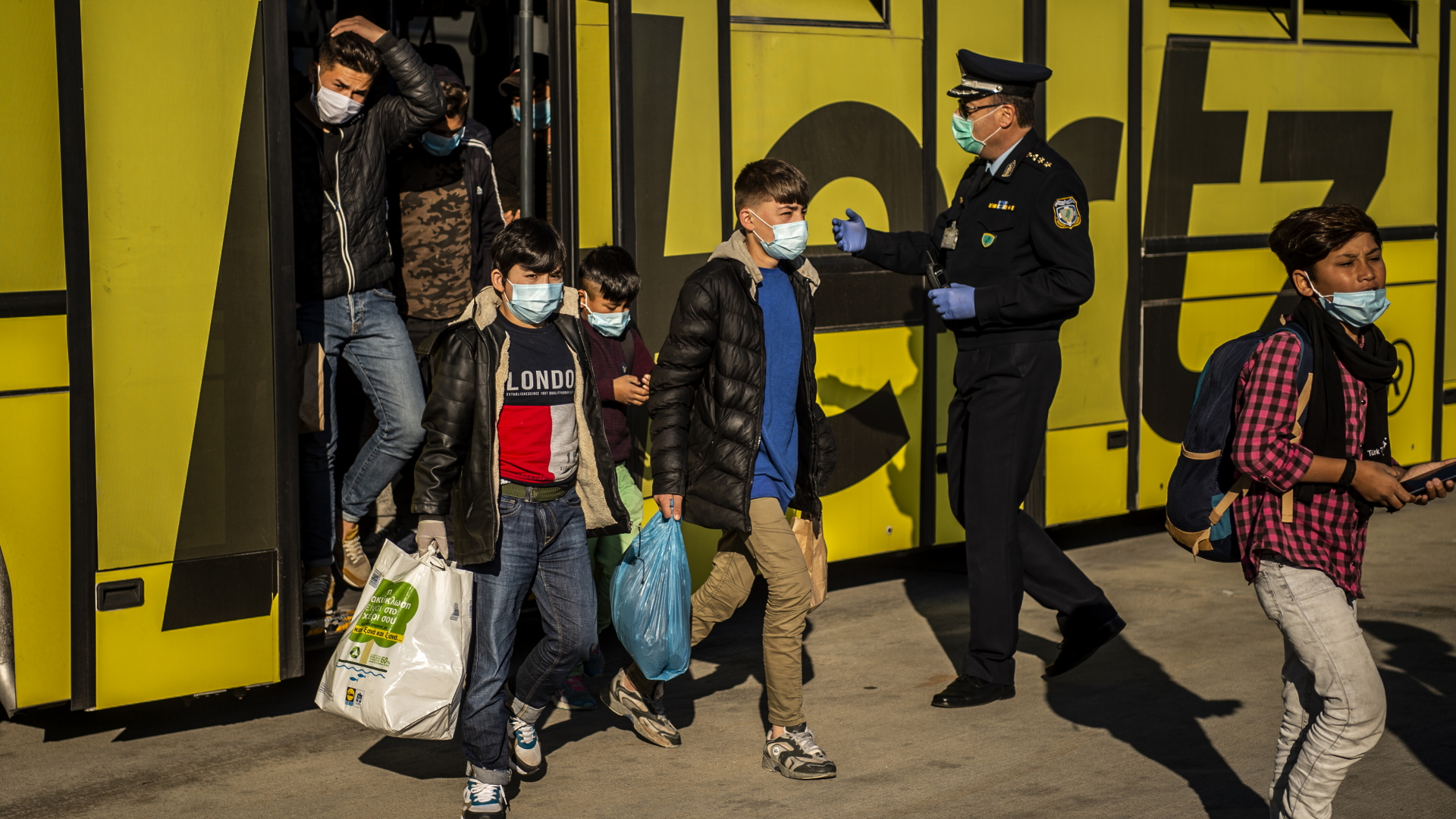 Minderjährige Flüchtlinge von griechischen Inseln gehen am Athener Flughafen zu einem Flugzeug, das sie nach Hannover bringen soll. | dpa