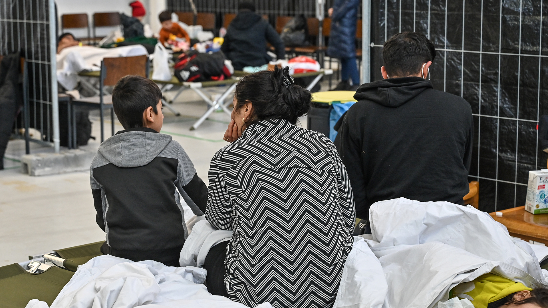 Migranten sitzen in der neu eingerichteten zentralen Bearbeitungsstelle der Bundespolizei und des Bundesamtes für Migration und Flüchtlinge | dpa