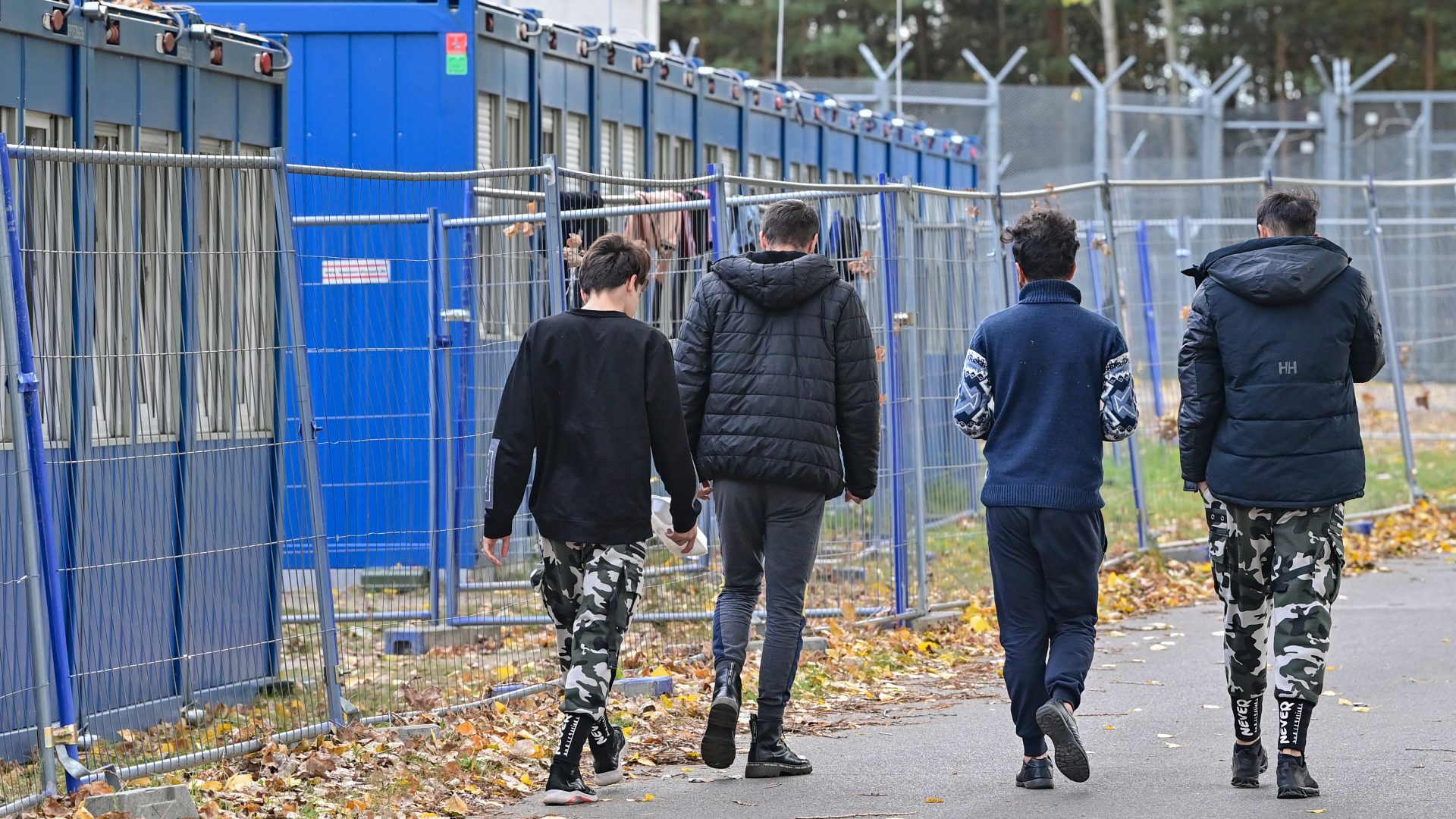 Flüchtlinge gehen über das Gelände der Zentralen Erstaufnahmeeinrichtung für Asylbewerber (ZABH) des Landes Brandenburg in Eisenhüttenstadt. | dpa