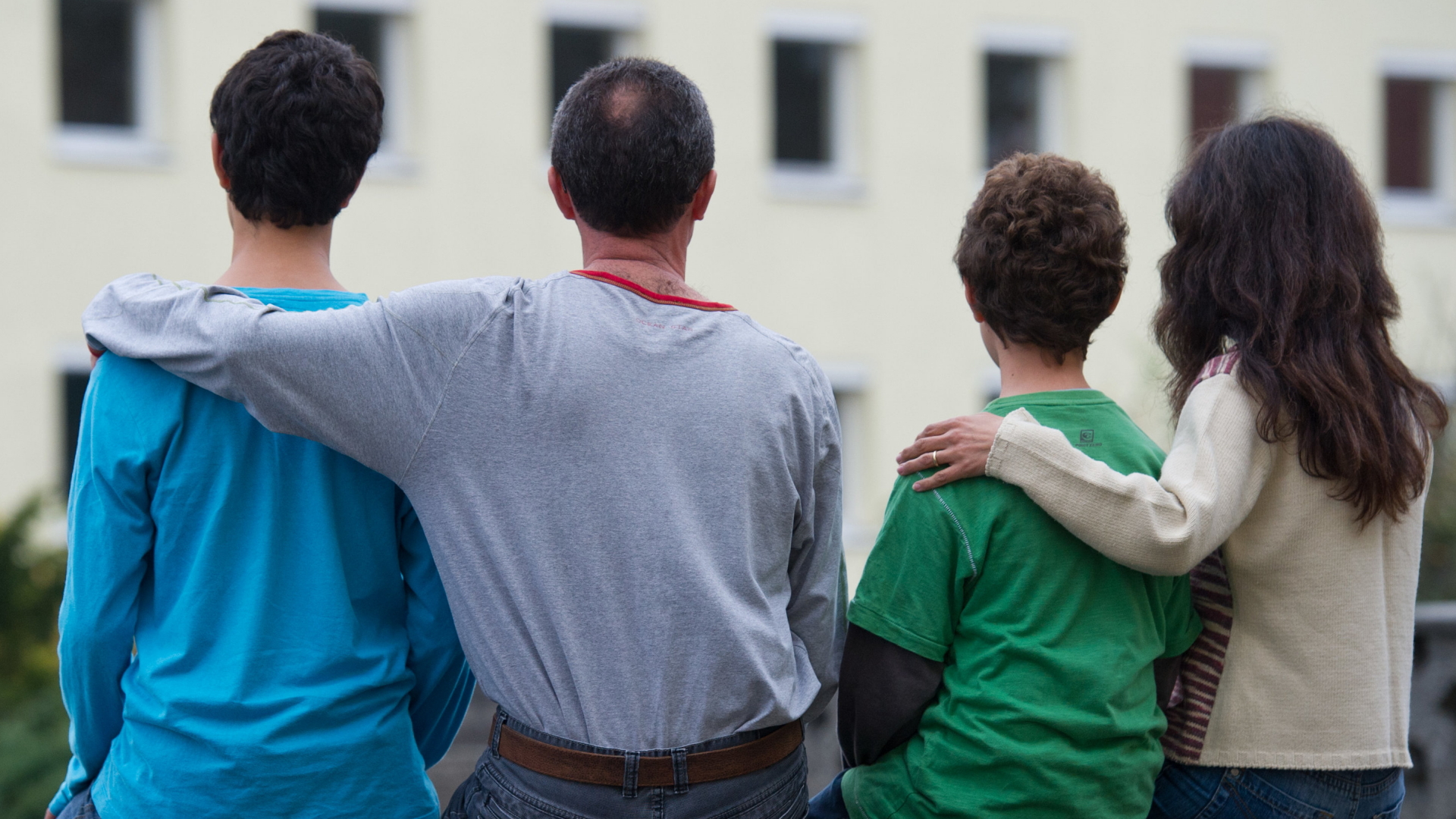 Eine syrische Familie sitzt vor einem Asylbewerberheim in Brandenburg