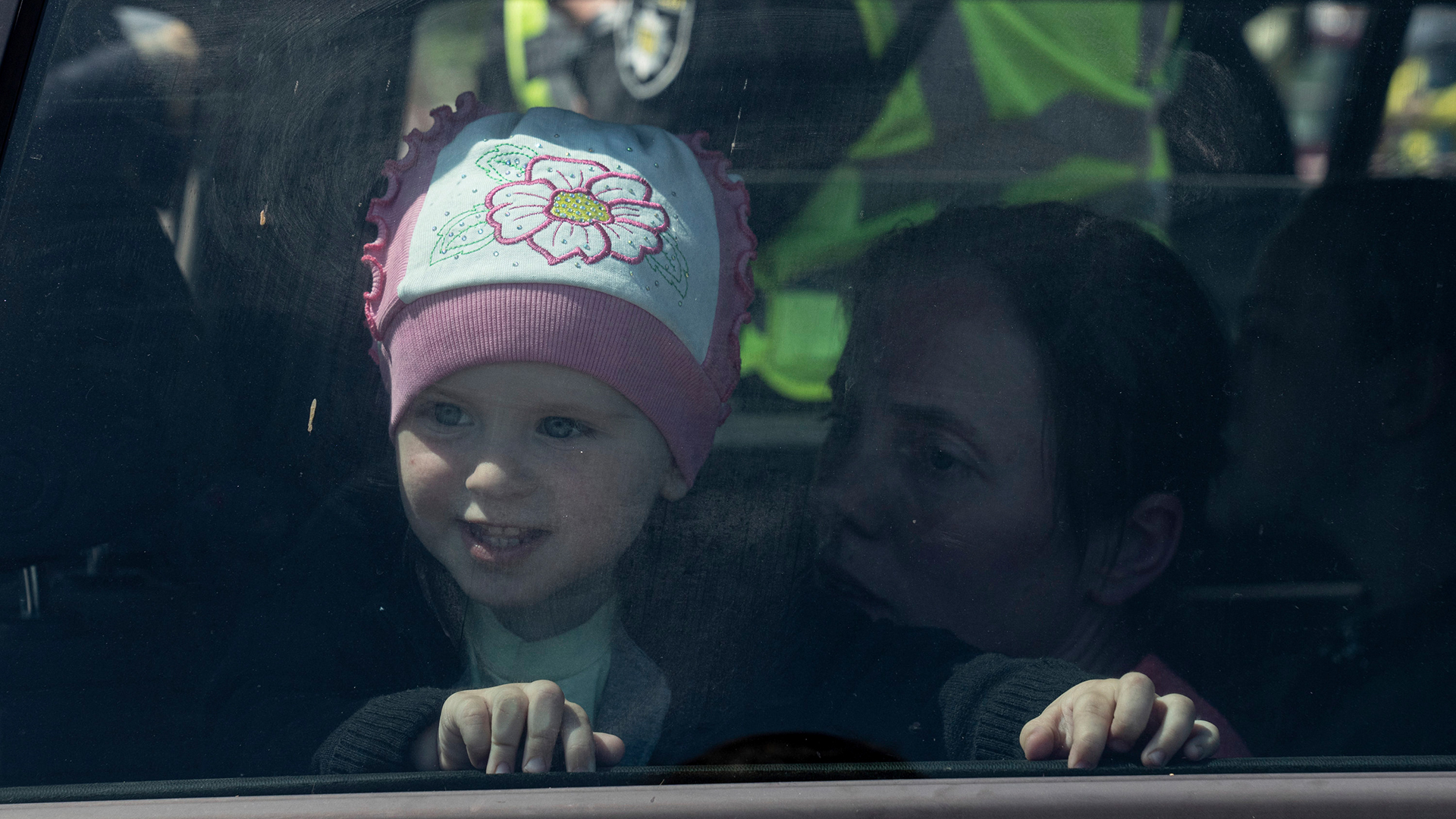 Ein Mädchen schaut durch das Fenster eines Autos, als ihre Familie aus Mariupol im Zentrum für Vertriebene in Saporischschja (Ukraine) ankommt. (Archivbild: 05. Mai 2022) | AP