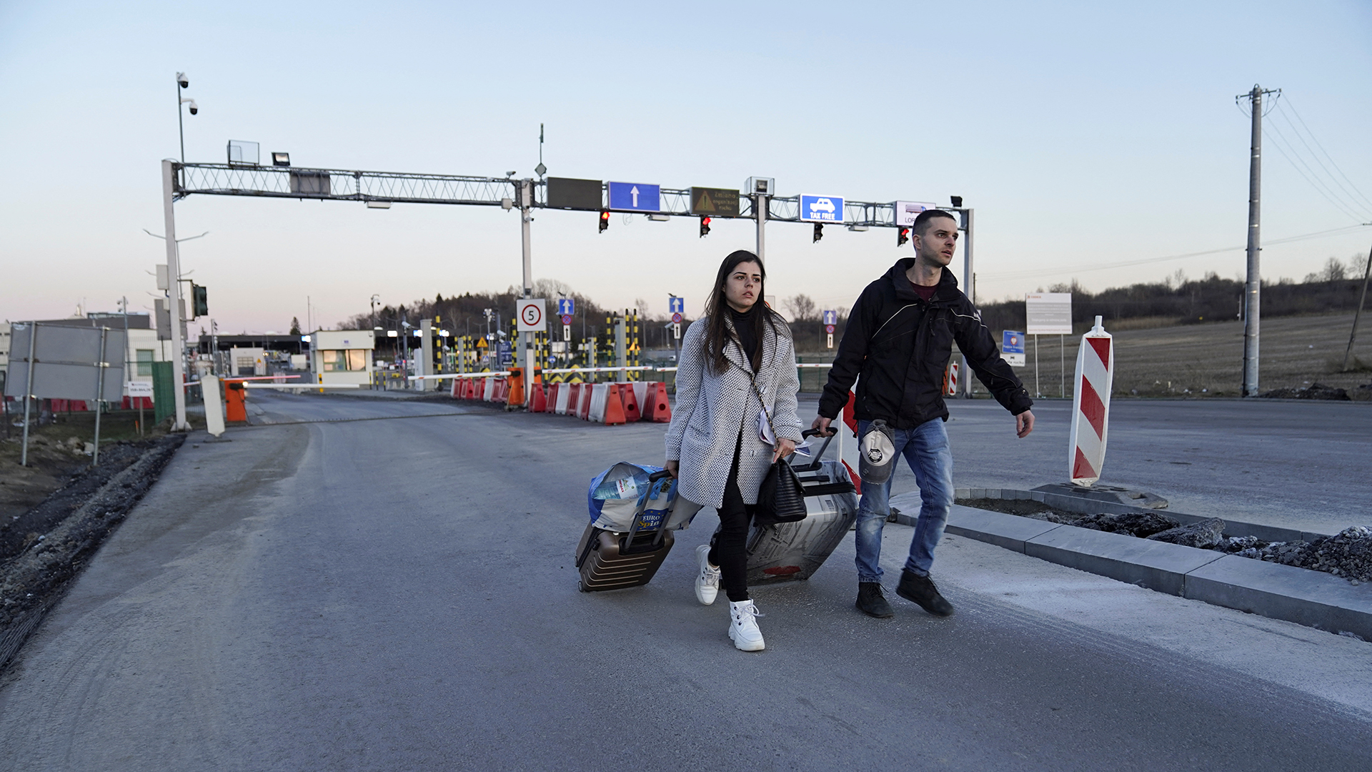 Ein Paar geht durch die Kontrolllinien am Grenzübergang in Medyka (Polen). | REUTERS