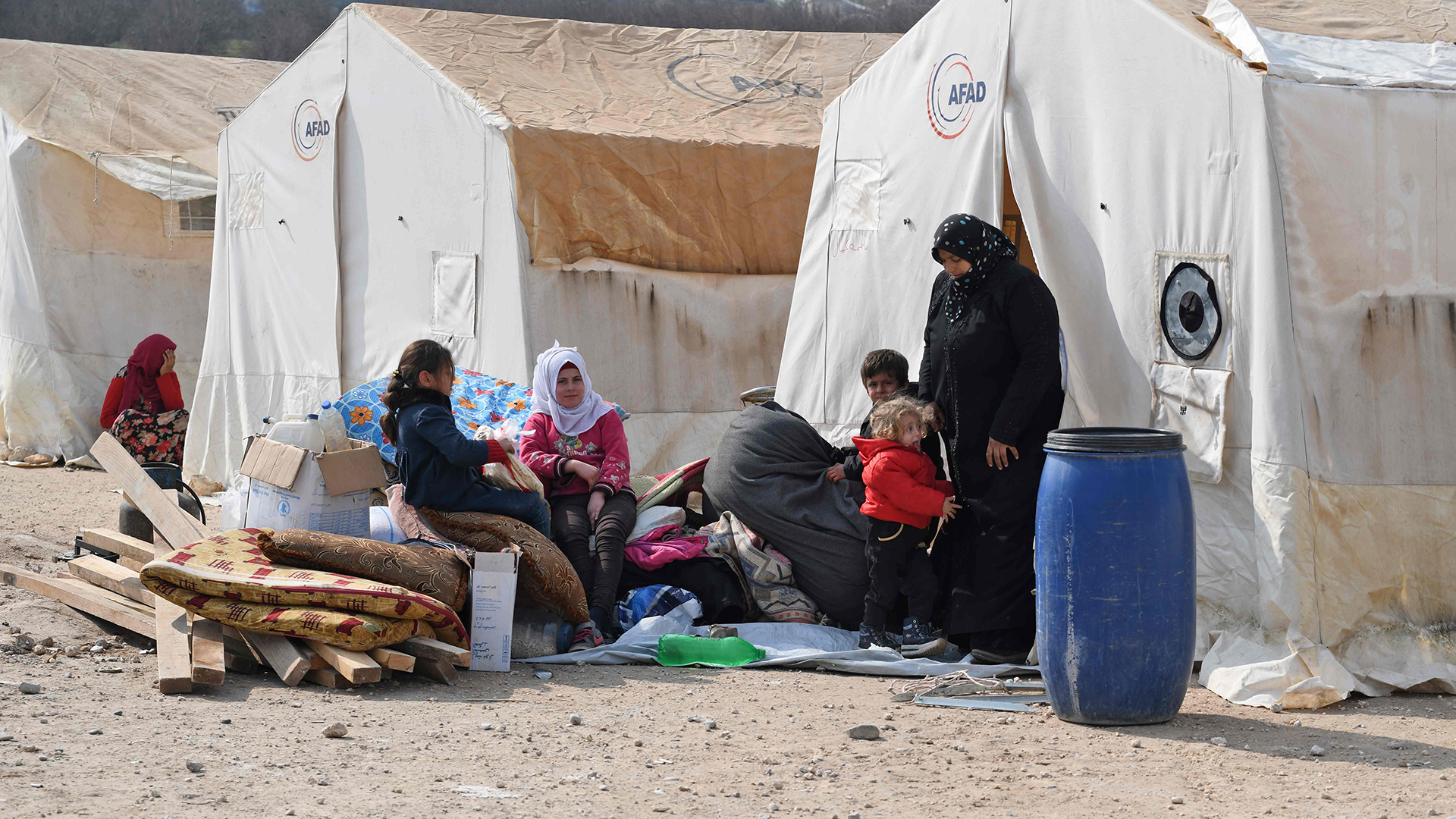 Vertriebene Syrer sitzen vor ihren Zelten im Lager Deir al-Ballut nahe der Grenze zur Türkei