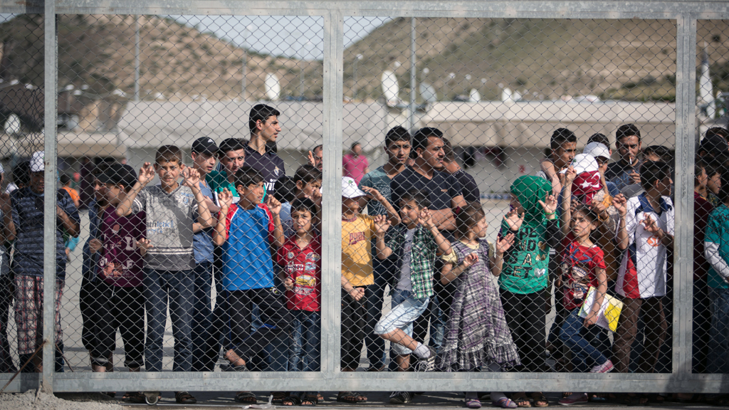 Flüchtlinge stehen hinter einem Zaun in Gaziantep, Türkei. | dpa