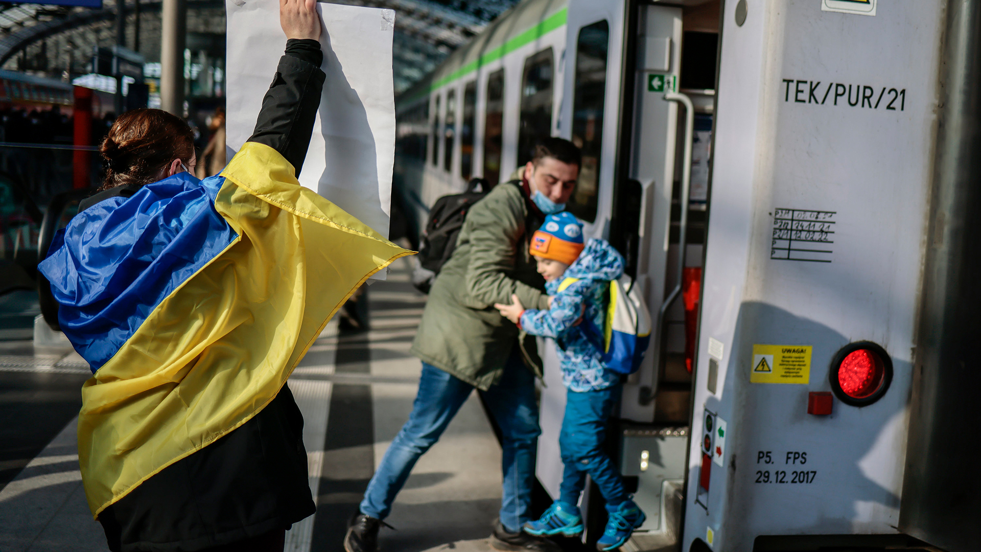 Eine Frau mit ukrainischer Fahne steht am Berliner Hauptbahnhof am ankommenden Zug aus Polen, mit dem Menschen aus Kiew einreisen. | AP