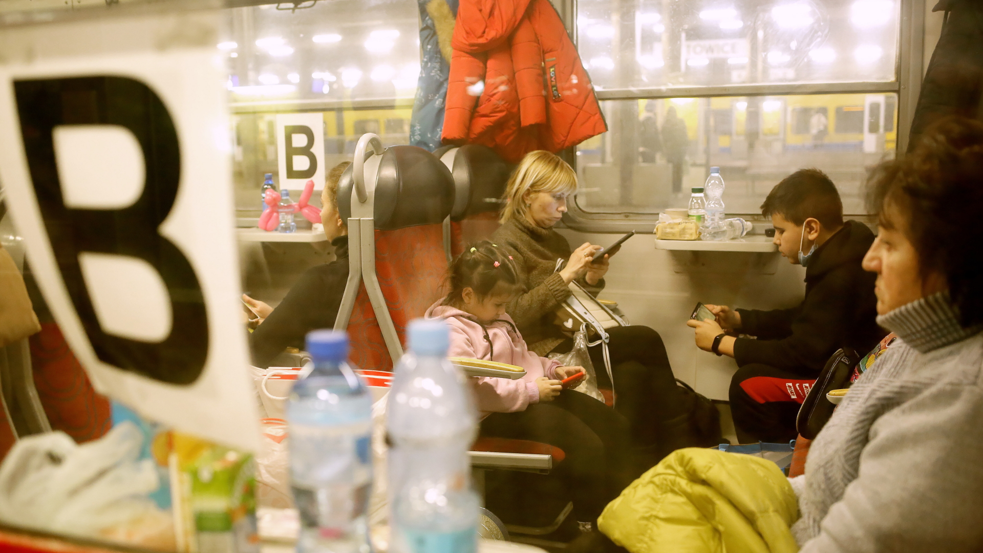 Kriegsflüchtlinge aus der Ukraine sitzen am Bahnhof Kattowitz in Polen in einem Personenzug nach Deutschland. | dpa