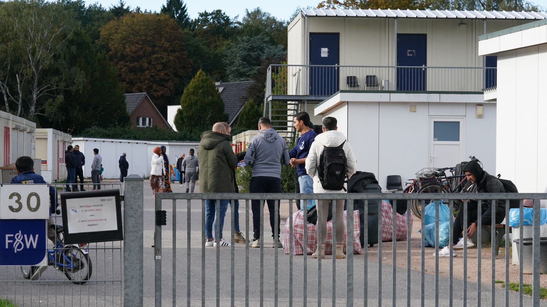 Flüchtlinge stehen auf dem Gelände der Flüchtlingsunterkunft in Hamburg.
