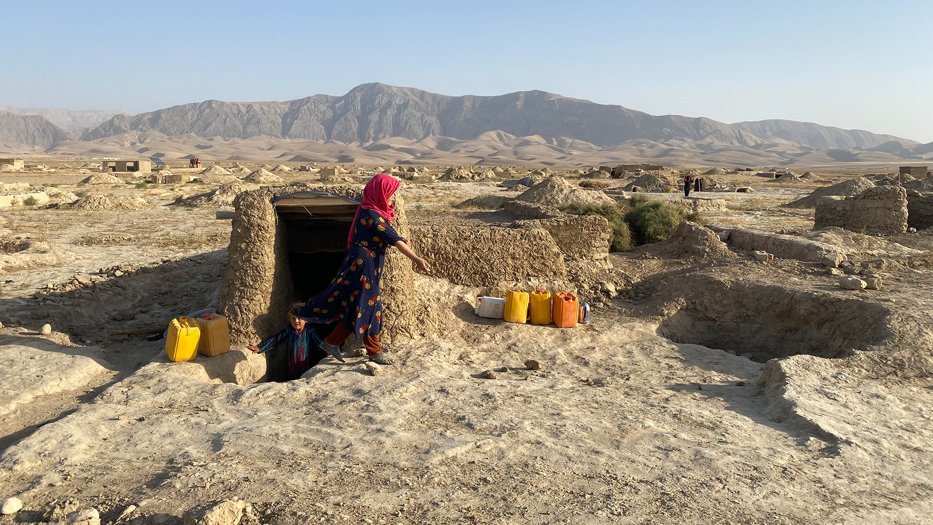 Eine Frau kommt im Flüchtlingslager Masar aus einem Eingang, Afghanistan. | Silke Diettrich