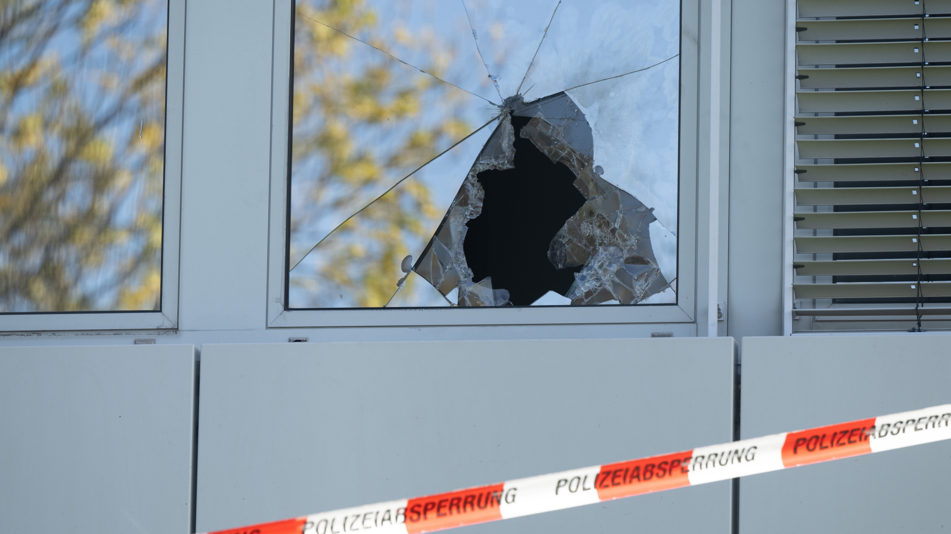 Ein Absperrband der Polizei hängt vor einer zerbrochenen Fensterscheibe einer geplanten Flüchtlingsunterkunft. | dpa