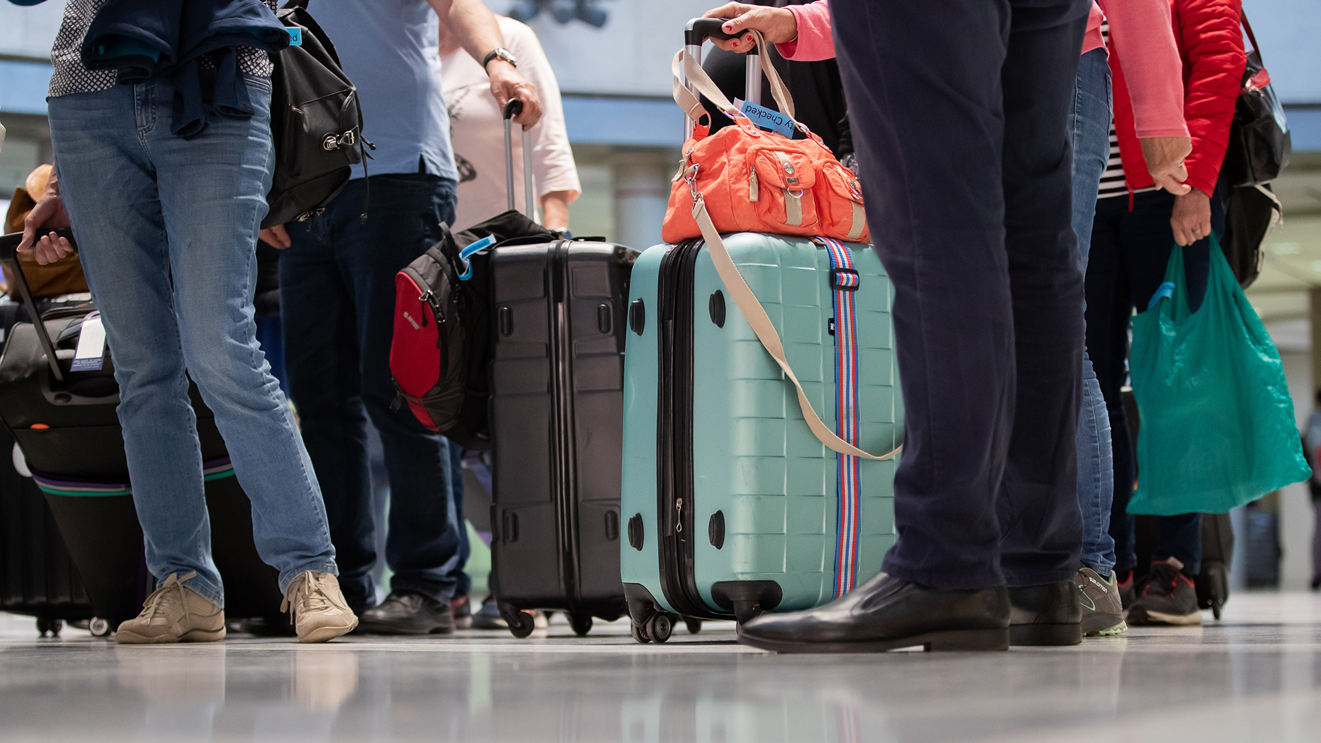 Passagiere stehen mit ihrem Gepäck im Flughafen