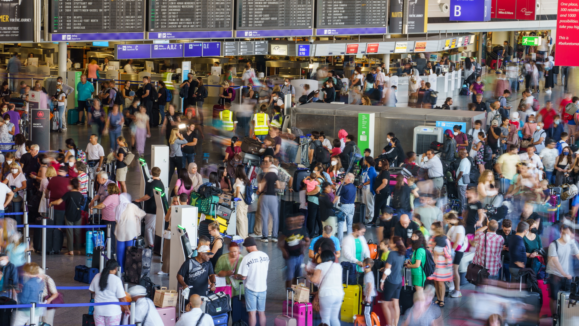 Reisende warten in langen Schlangen und dichtgedrängt im Terminal 1 des Frankfurter Flughafens am Check-In (Aufnahme mit längerer Belichtungszeit, Archivbild).  | dpa