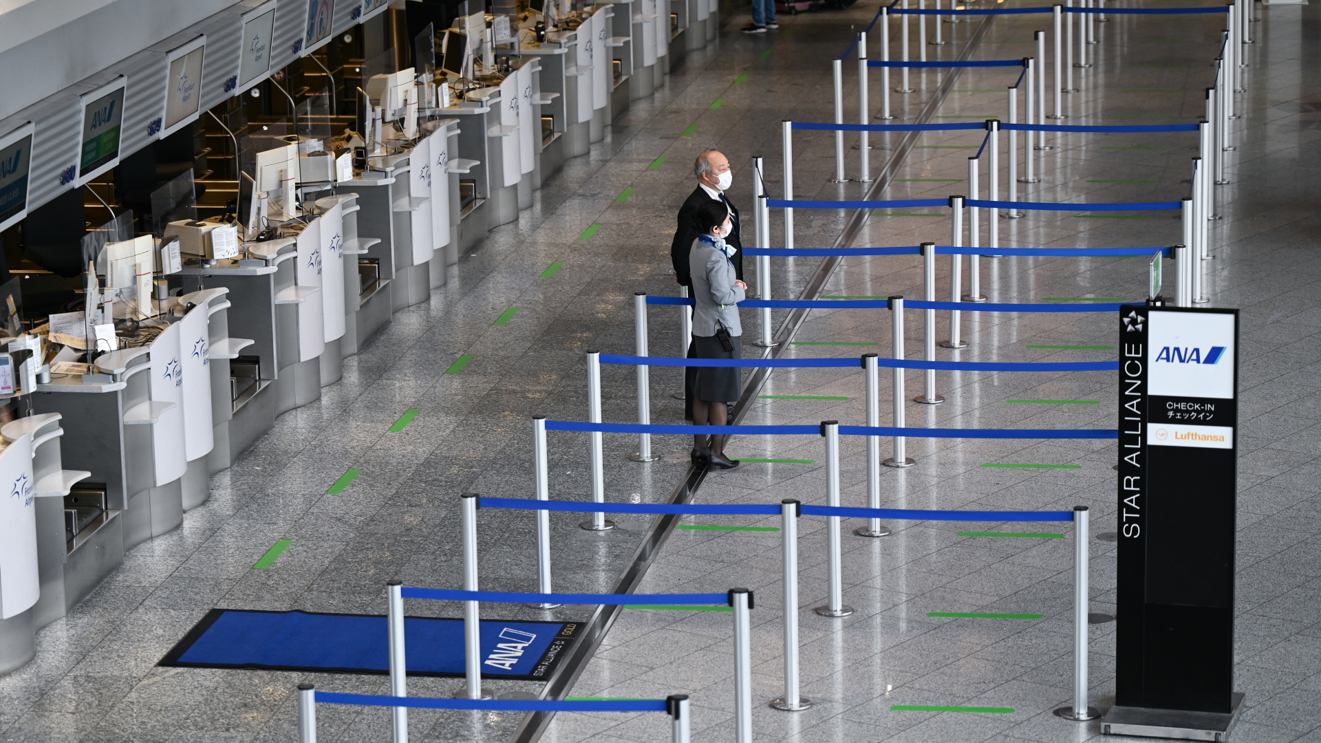 Mitarbeiter einer Fluggesellschaft stehen am Frankfurter Flughafen vor leeren Abflugschaltern. | dpa