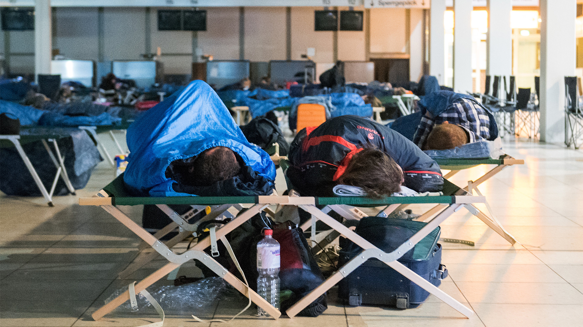 Reisende schlafen am Helmut-Schmidt-Airport im ''Terminal Tango'' auf Feldbetten | dpa