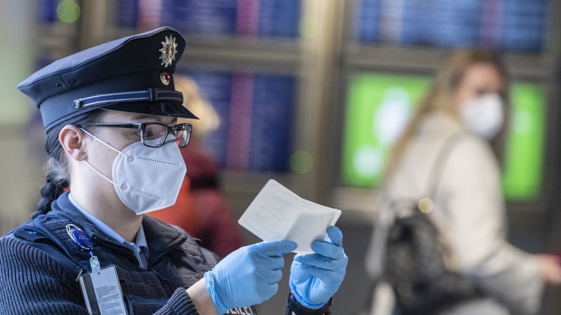 Eine Beamtin der Bundespolizei kontrolliert am Flughafen Frankfurt ein Dokument eines Passagiers. | dpa