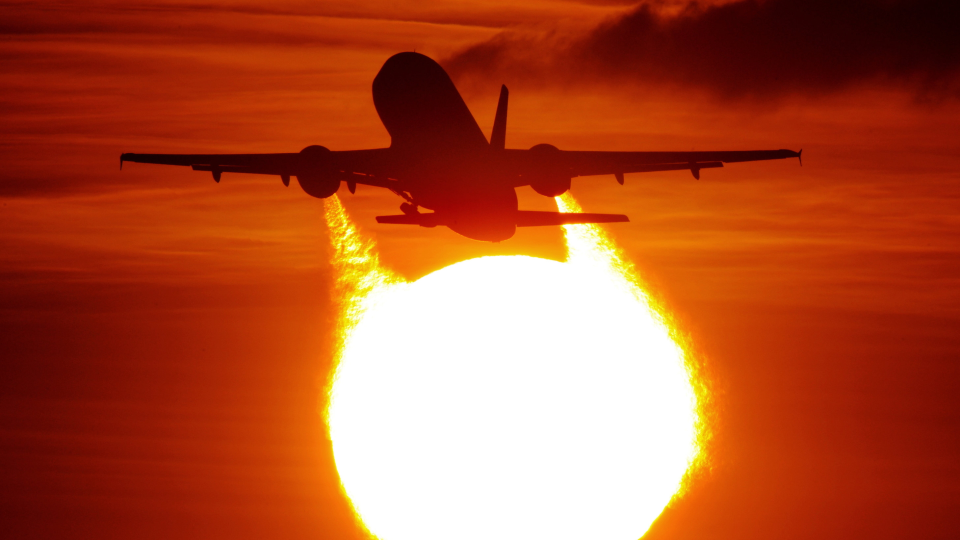 Ein Flugzeug startet am Flughafen in Düsseldorf vor der untergehenden Sonne. | dpa