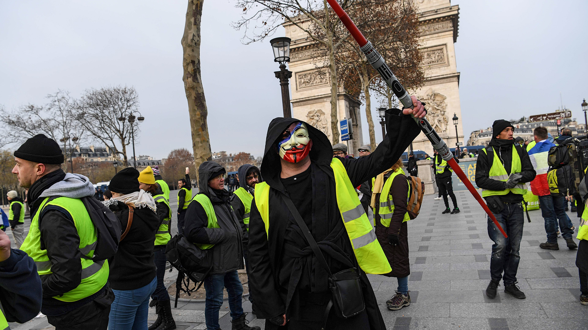 Ein Mann mit Anonymous-Maske und gelber Weste | Bildquelle: AFP