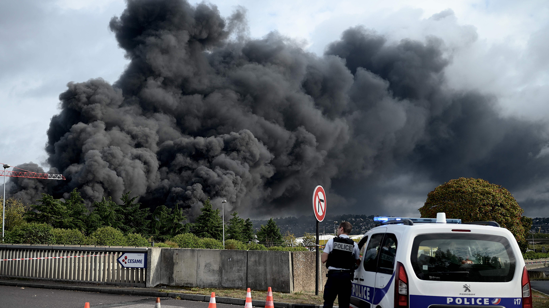 Polizist vor dunklen Rauchwolken über Rouen | AFP