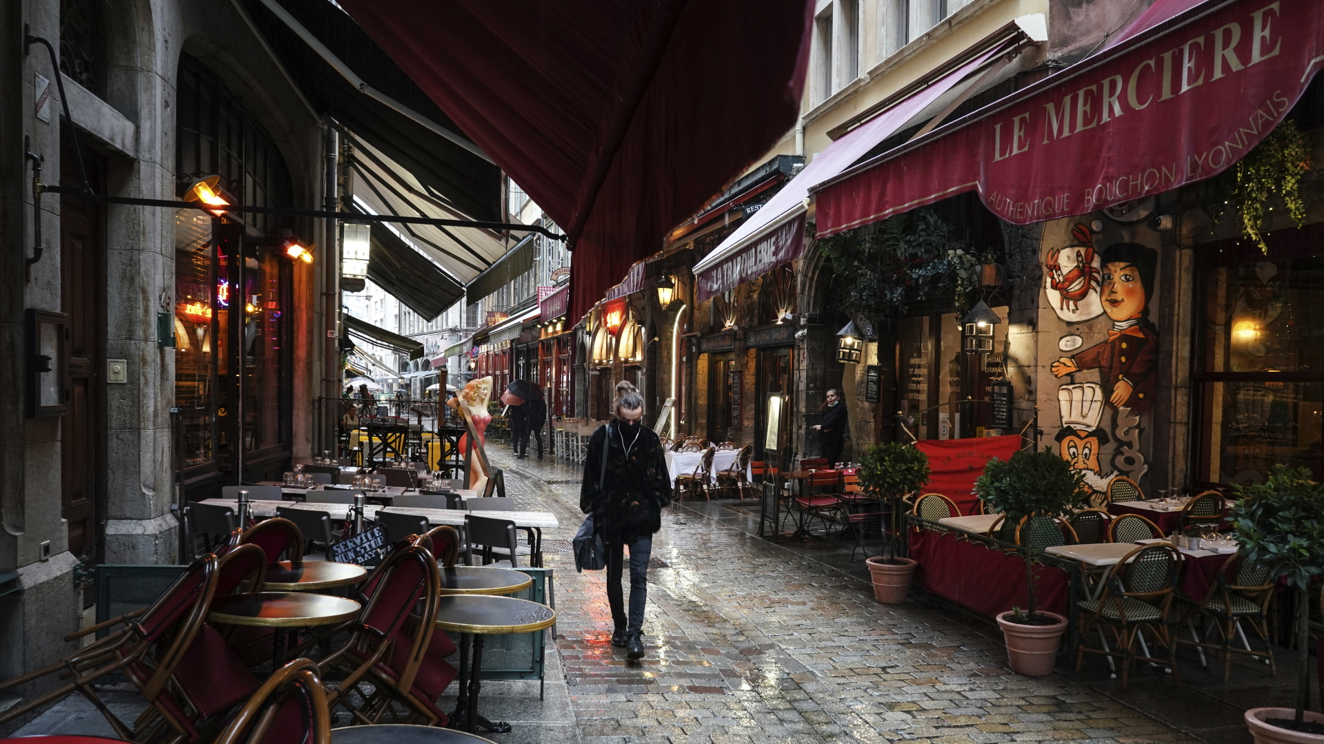 Eine Frau geht an leeren Restaurants im Zentrum von Lyon vorbei.  | dpa