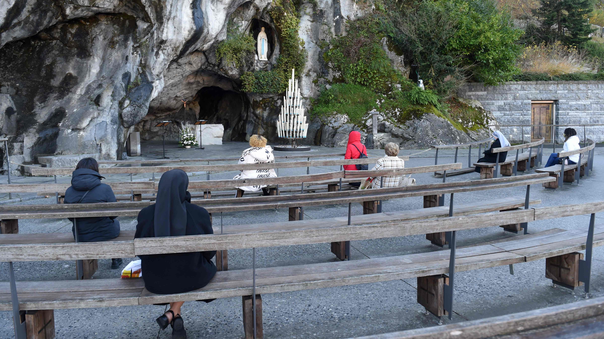 Menschen beten vor der wegen der Corona-Pandemie geschlossenen  Grotte von Massabielle im französischen Lourdes. | AFP
