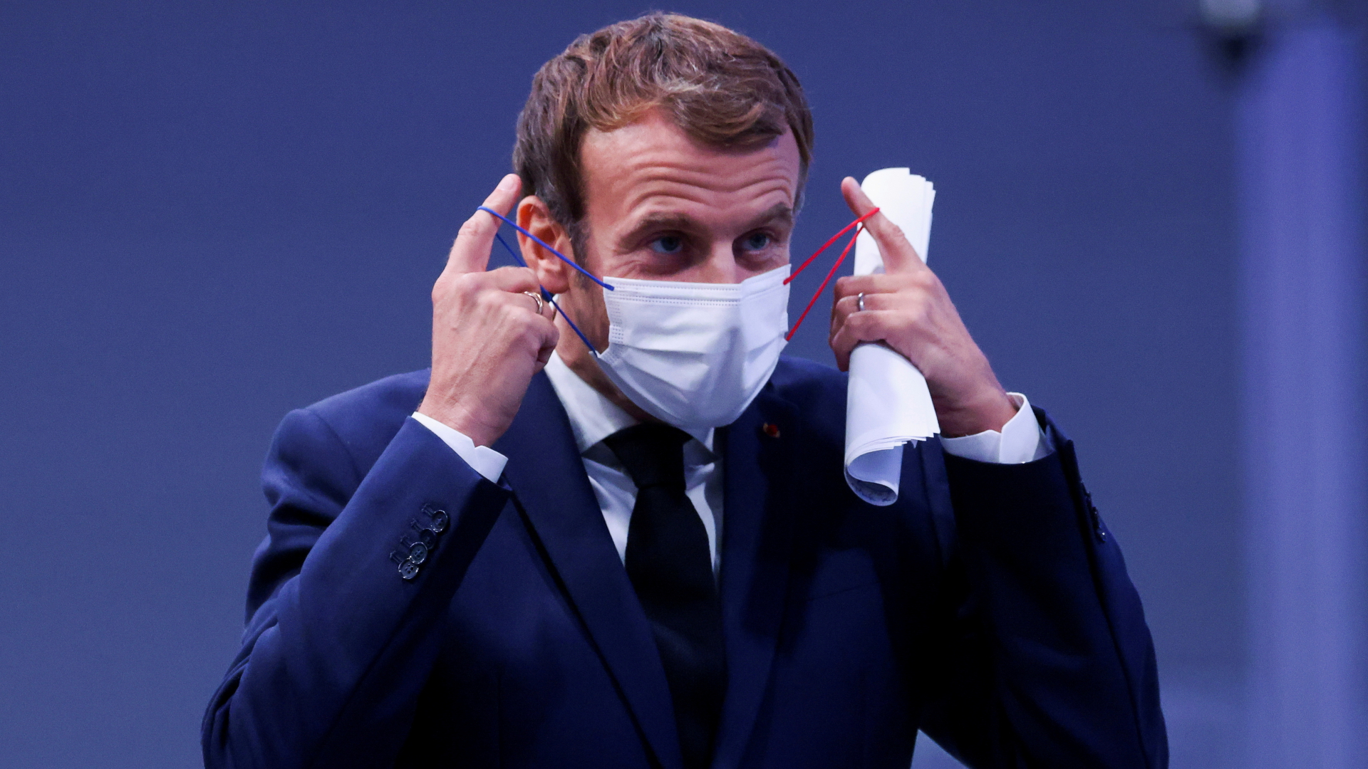 Frankreichs Präsident Emmanuel Macron nimmt  eine Corona-Schutzmaske ab. | REUTERS