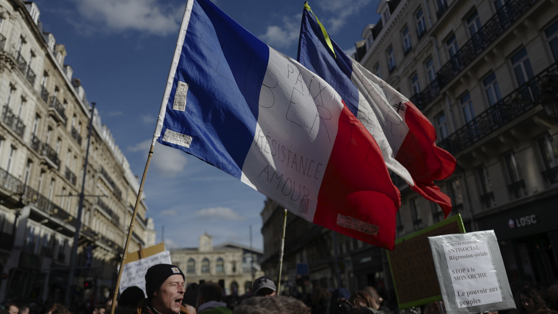 Zwei französische Flaggen wehen bei einem Protest gegen die geplante Rentenreform im Wind. | AP