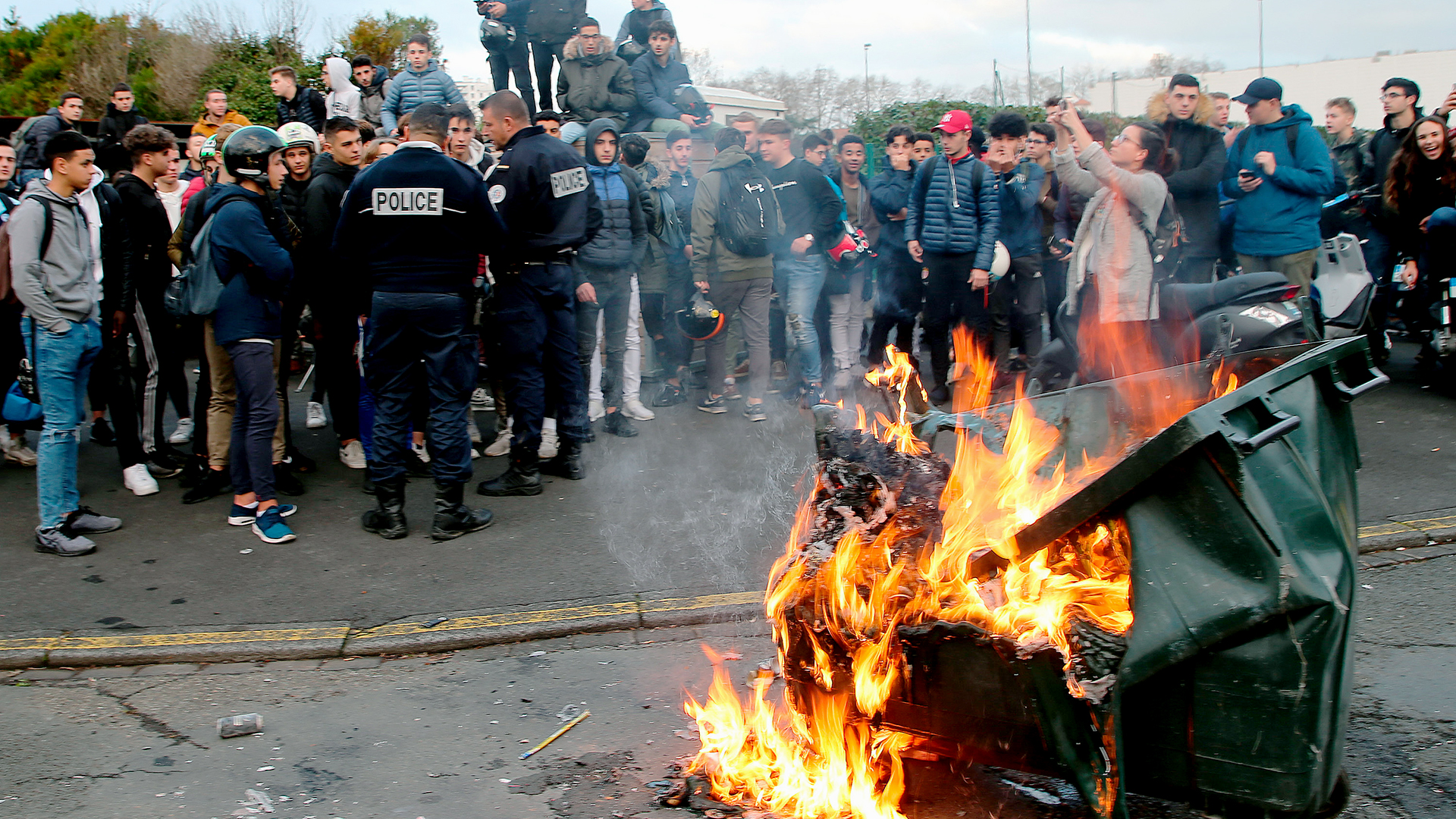 Schüler in Bayonne stehen um eine brennende Mülltonne herum | Bildquelle: dpa