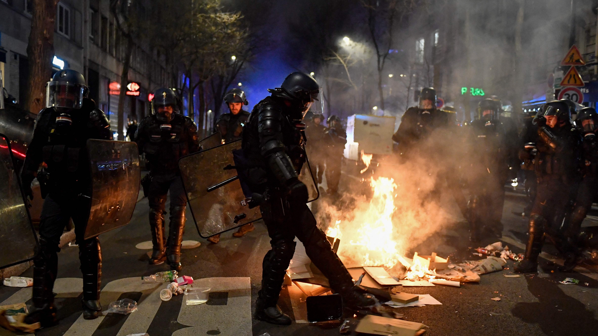 Ein Polizist versucht ein Feuer bei Protesten in Paris auszutreten | AFP