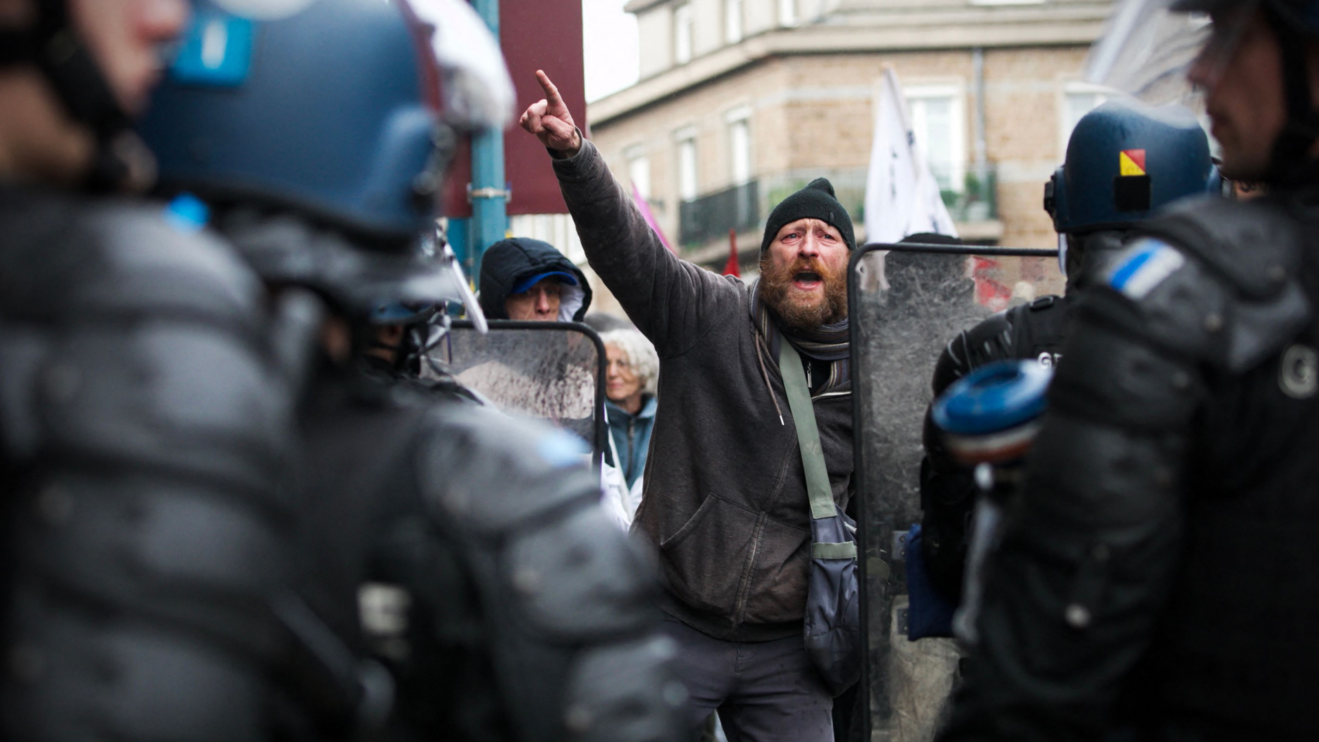 Ein Demonstrant gestikuliert vor französischen Gendarmen. | dpa