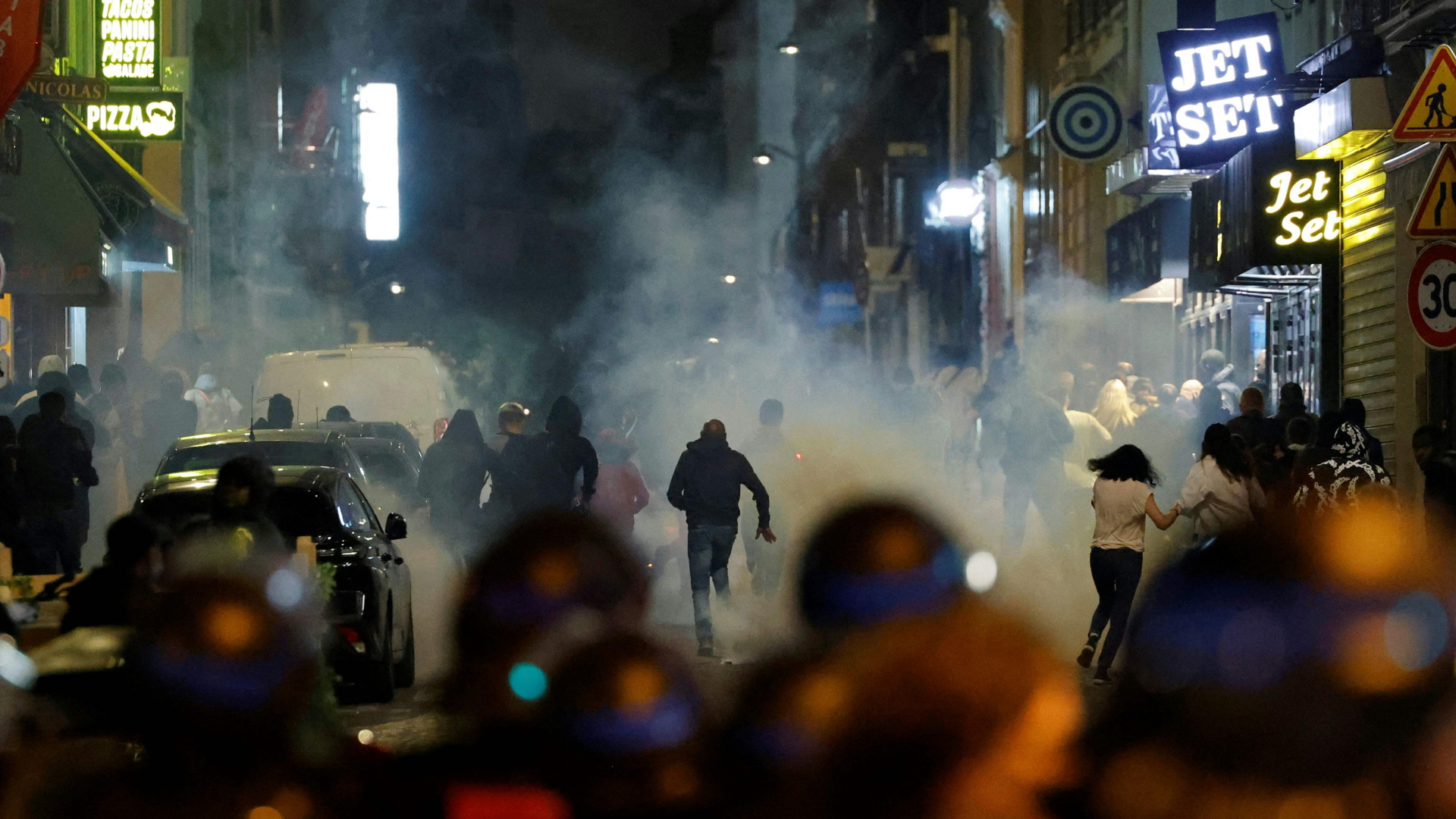 Demonstranten rennen in Paris, nachdem die Polizei Tränengas eingesetzt hat.